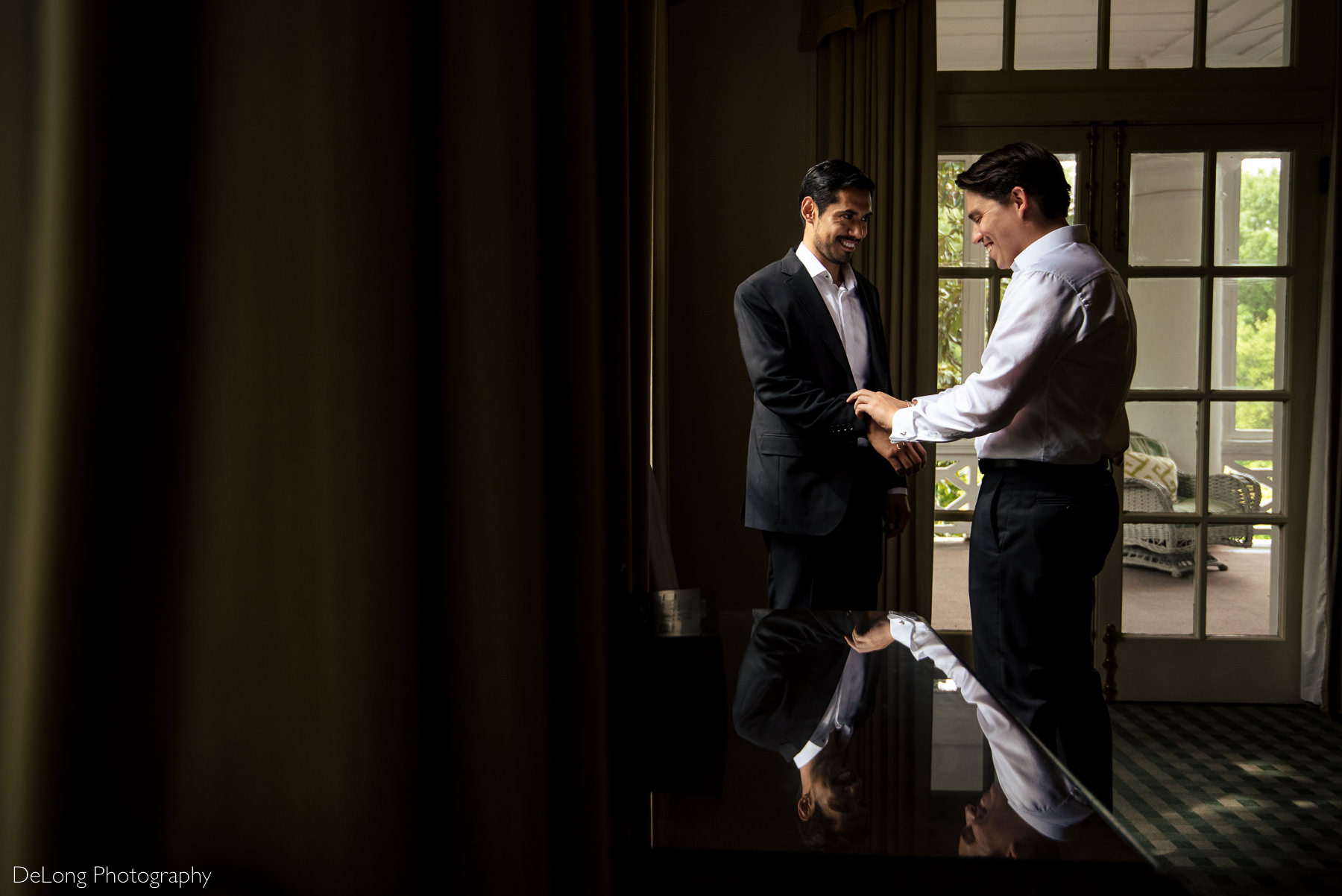 Two grooms helping each other get ready for their elopement at the Duke Mansion by Charlotte wedding photographers DeLong Photography