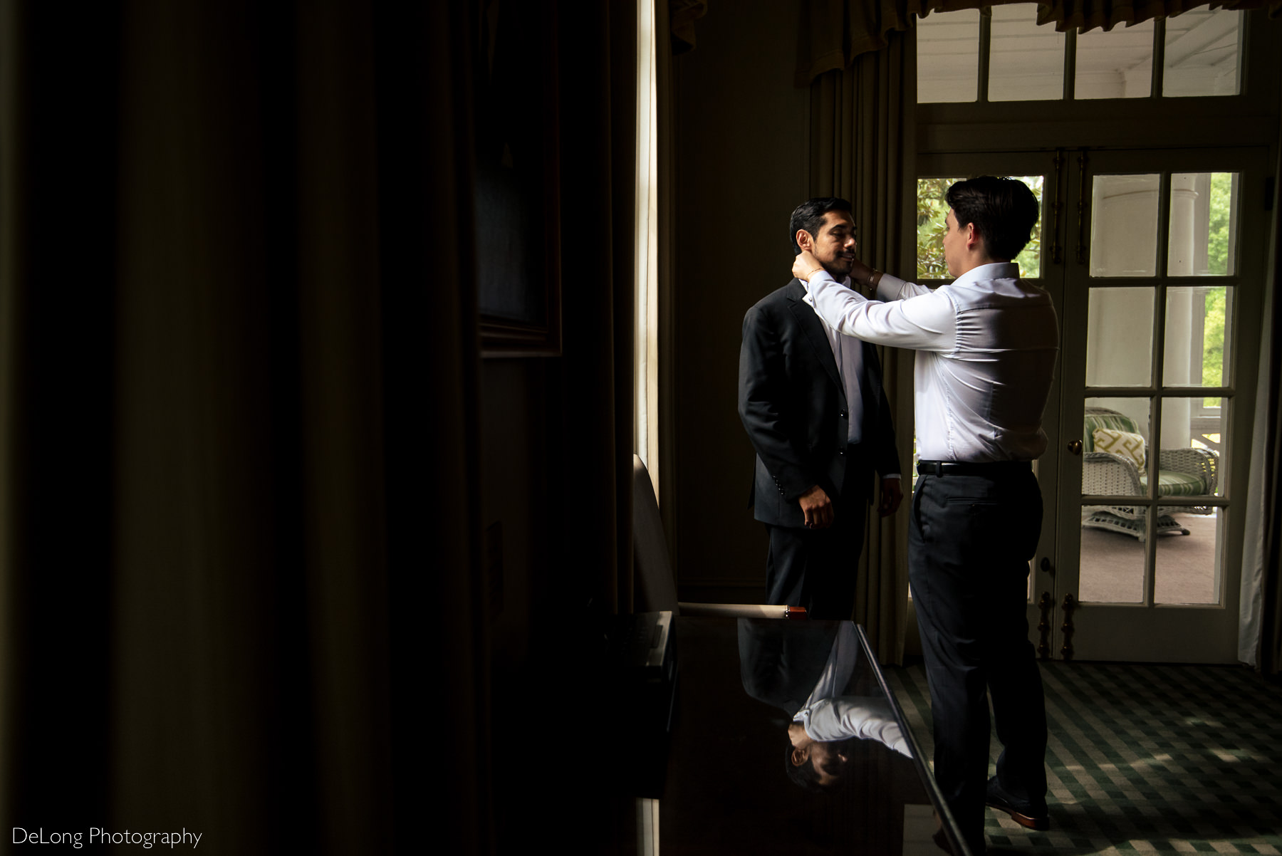 Two grooms helping each other get ready for their elopement at the Duke Mansion by Charlotte wedding photographers DeLong Photography