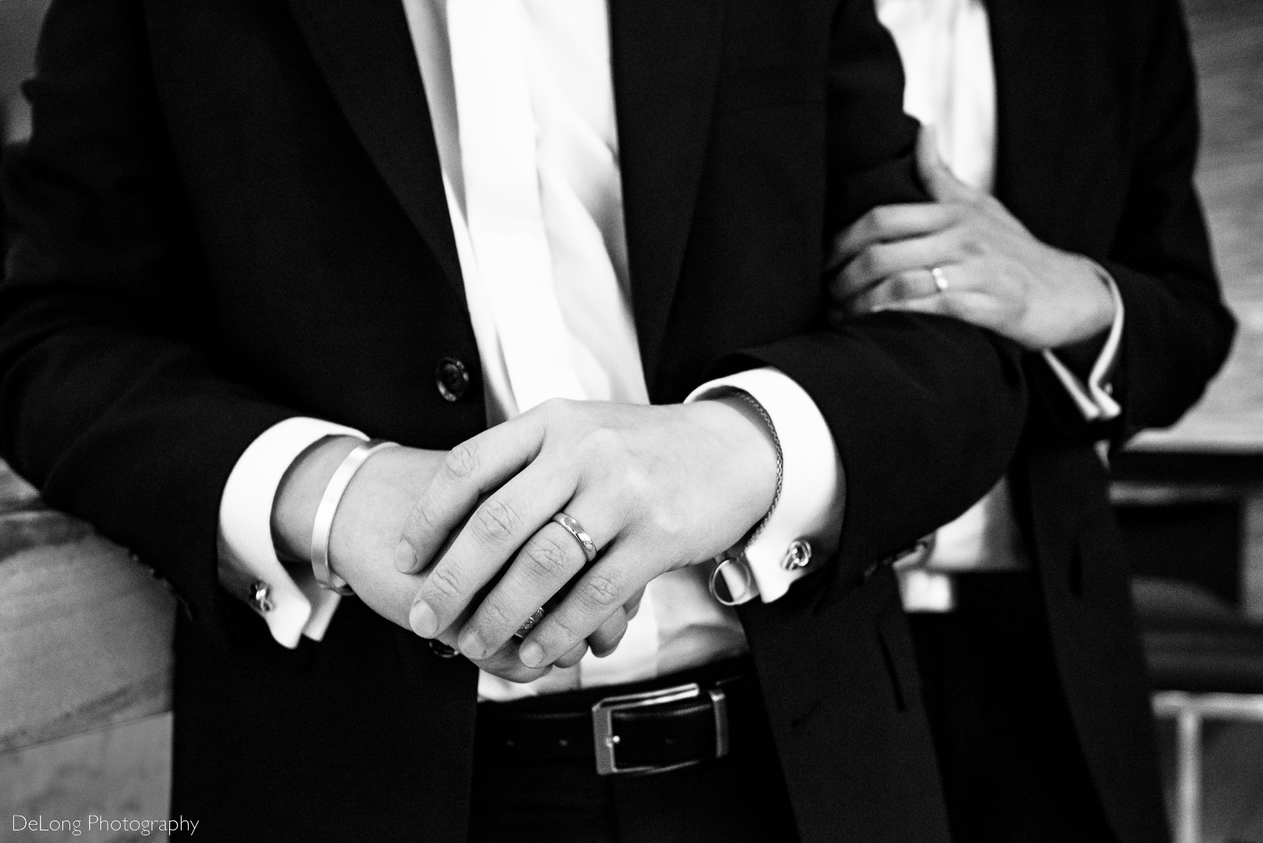 Black and white photograph showcasing the hands and wedding bands of gay couple by Charlotte wedding photographers DeLong Photography