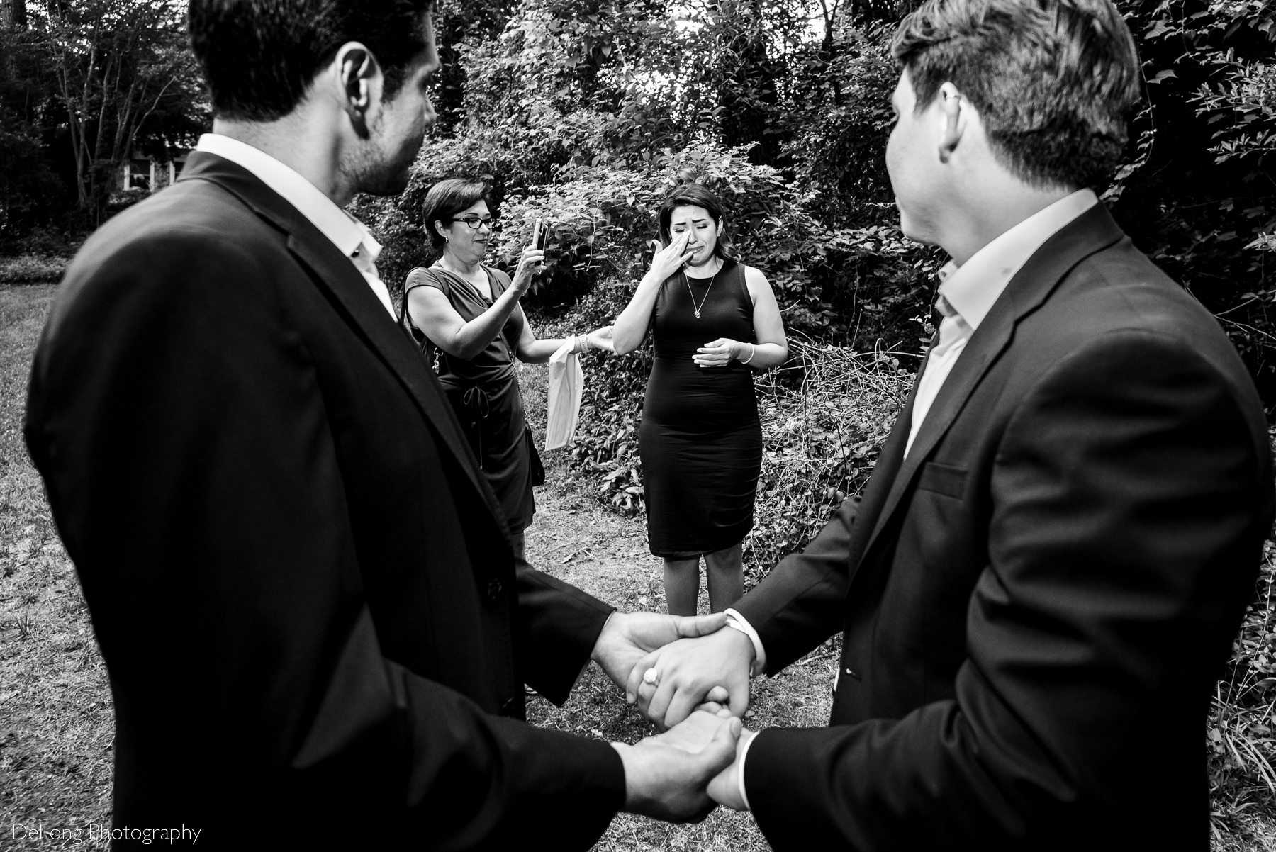 Black and white candid tearful moment of joy during a same-sex elopement by Charlotte wedding photographers DeLong Photography