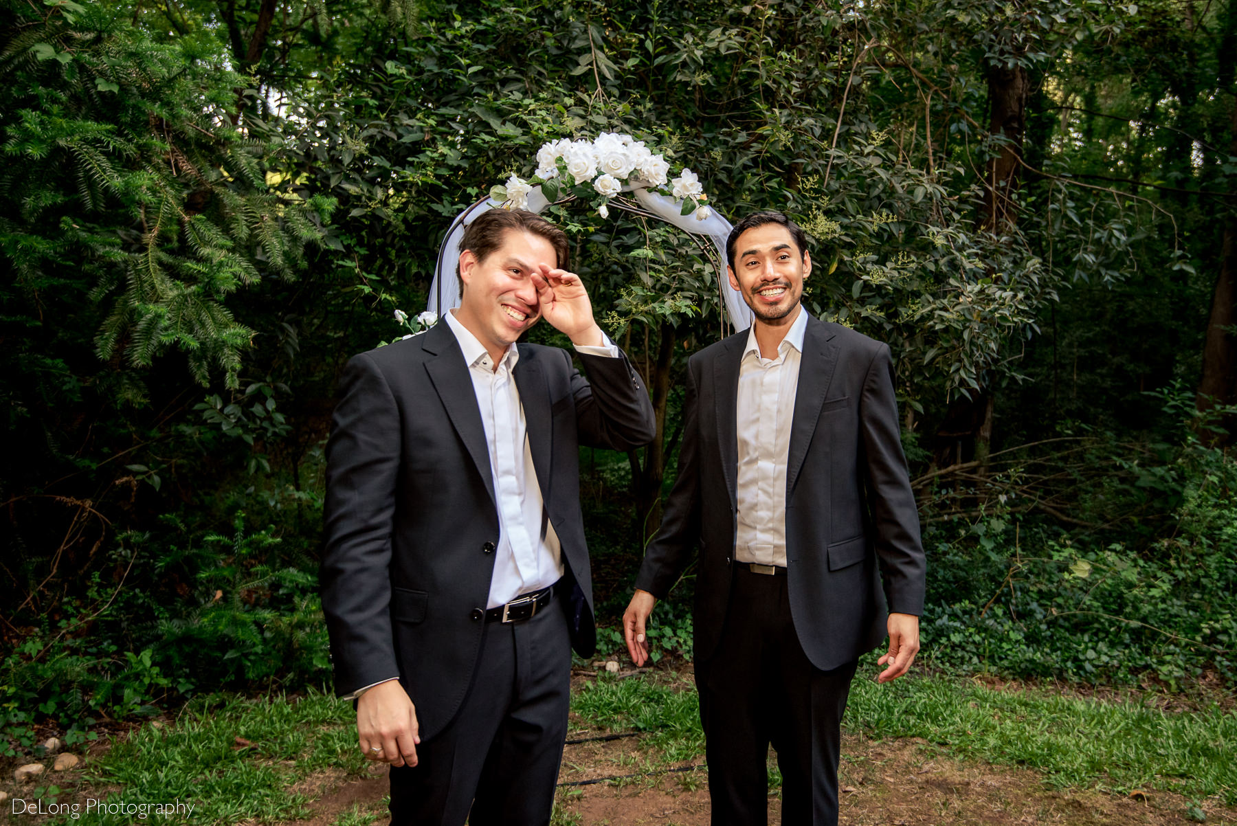 Candid photo of groom wiping tears from his eyes after a same-sex wedding ceremony by Charlotte wedding photographers DeLong Photography