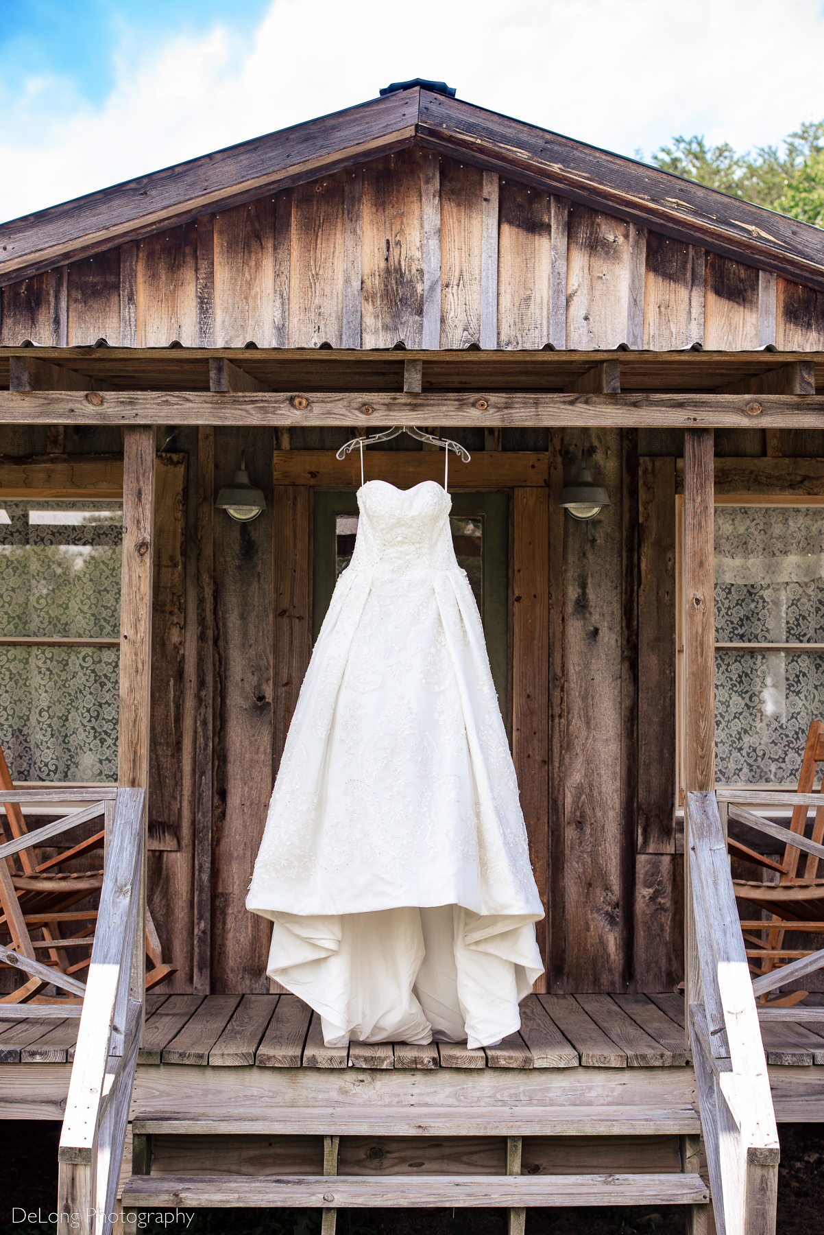 Bride's wedding dress hanging on the outside of the bridal suite at Lady Bird Farms by Charlotte Wedding Photographers DeLong Photography