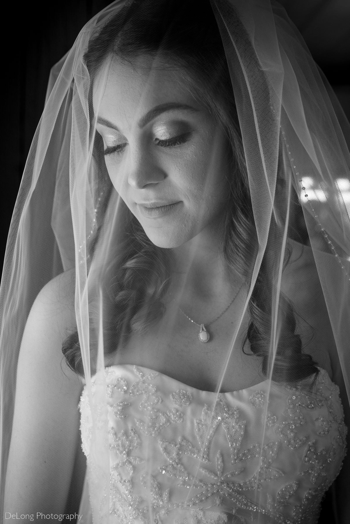 Black and white close crop portrait of a bride wearing her veil over in preparation for her wedding ceremony by Charlotte Wedding Photographers DeLong Photography