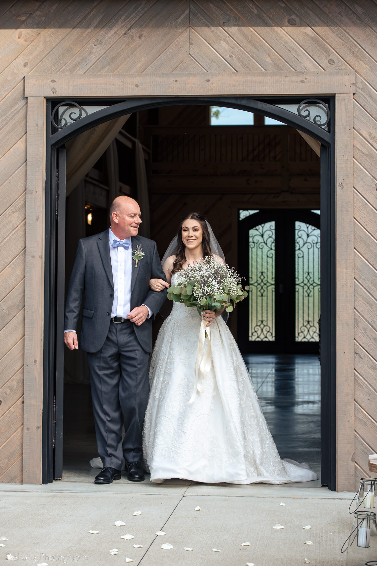 Bride entering outdoor ceremony space at Lady Bird Farms by Charlotte Wedding Photographers DeLong Photography