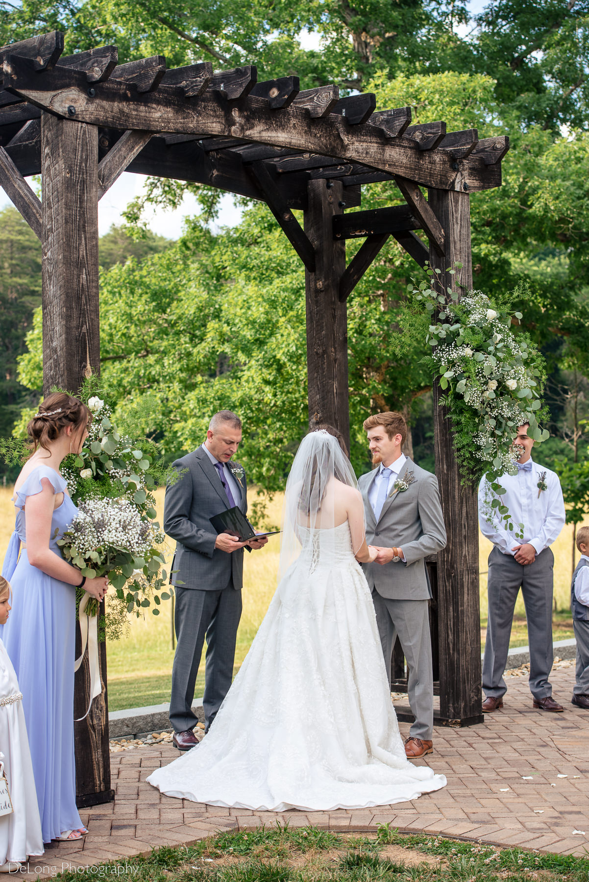 Bride and groom standing at the altar during their wedding ceremony at Lady Bird Farms by Charlotte Wedding Photographers DeLong Photography
