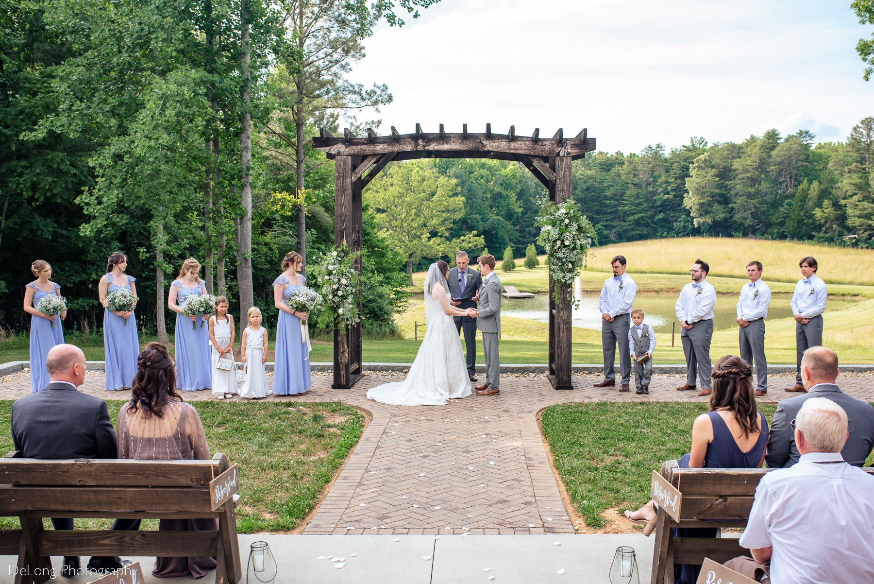 Wide angle image of wedding ceremony at the pond of Lady Bird Farms by Charlotte Wedding Photographers DeLong Photography