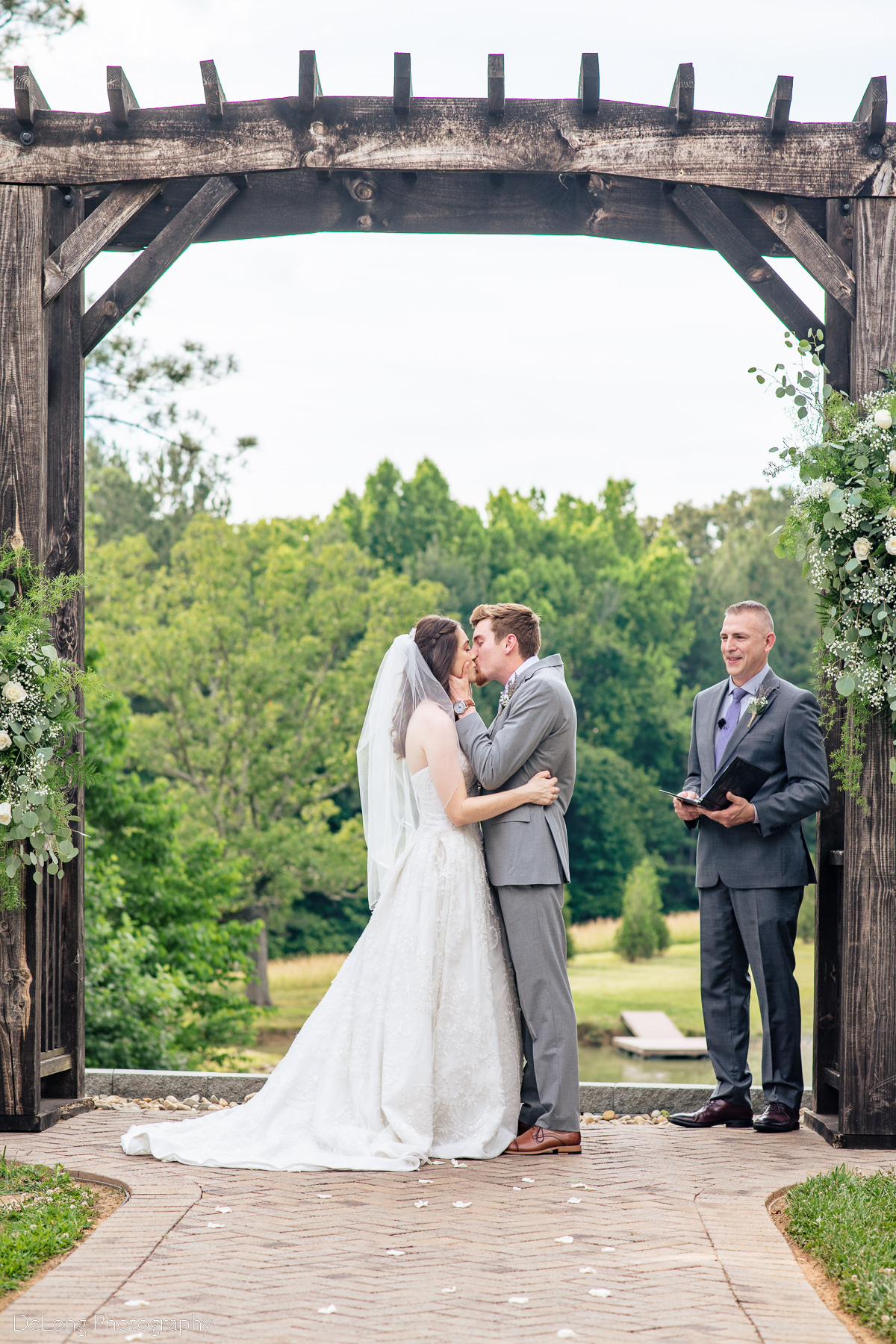 Bride and groom's first kiss at Lady Bird Farms by Charlotte Wedding Photographers DeLong Photography