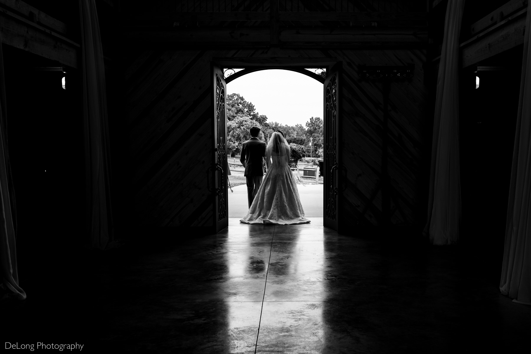 Silhouette of bride and groom as the exit the front of the barn at Lady Bird Farms by Charlotte Wedding Photographers DeLong Photography