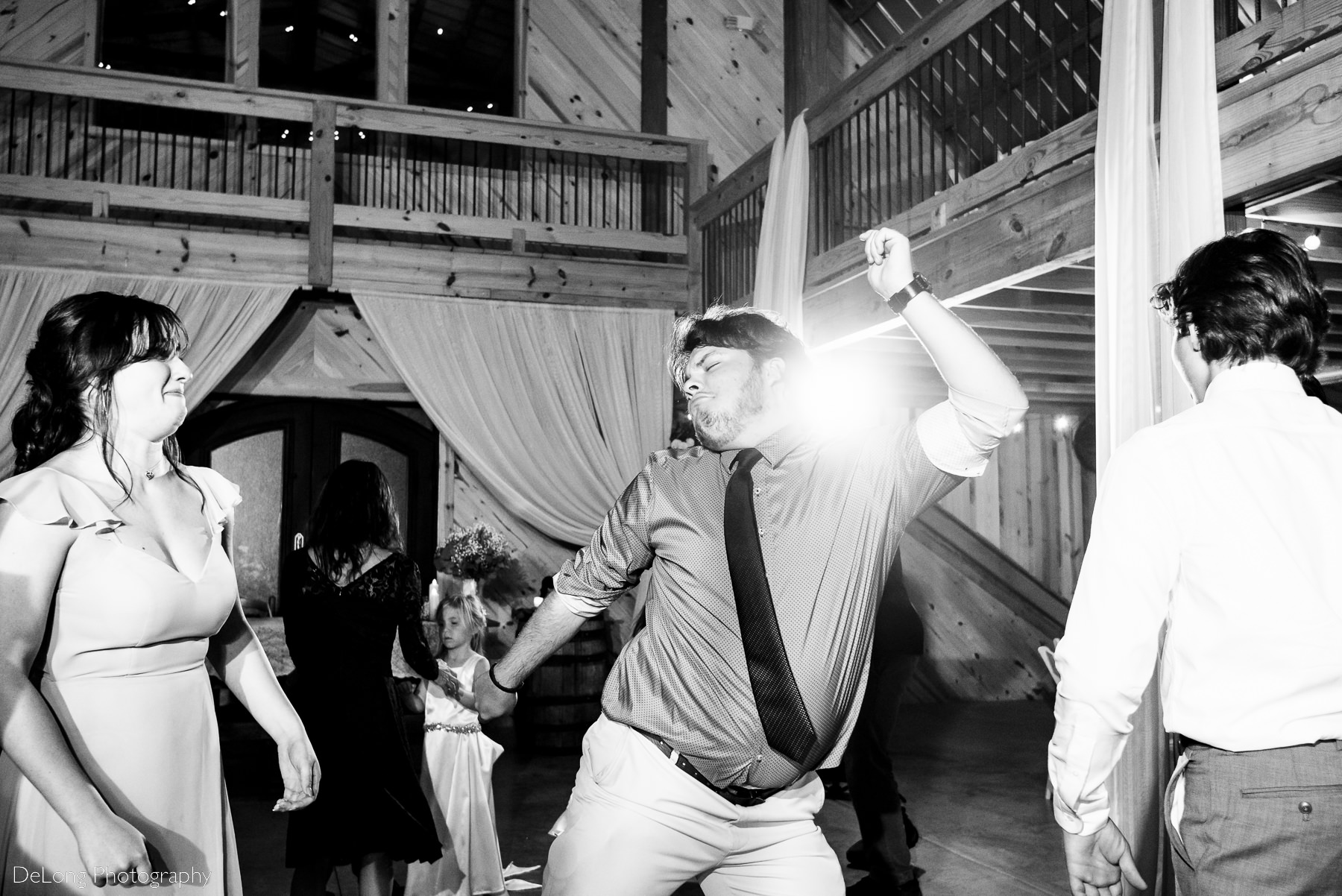 Wedding guest doing funny dance moved during wedding reception at Lady Bird Farms by Charlotte Wedding Photographers DeLong Photography