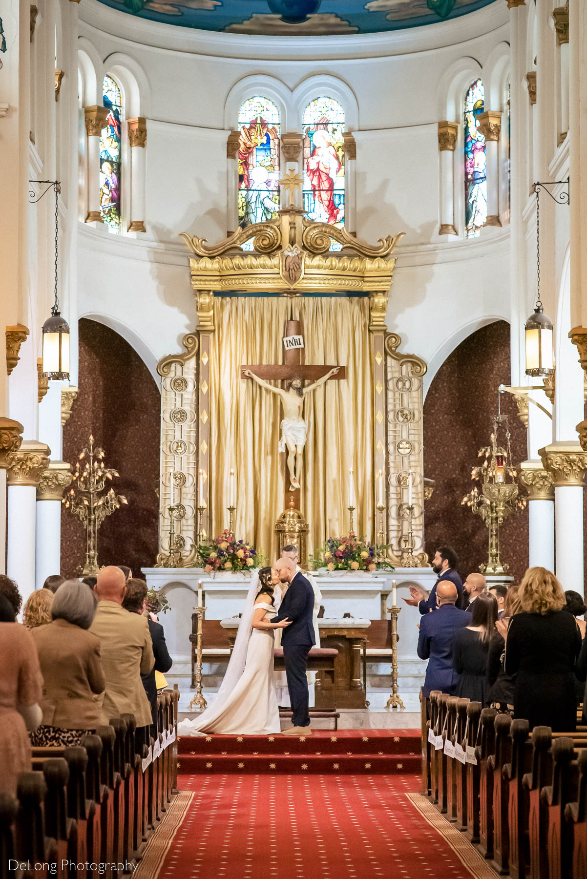Bride and groom first kiss at the Basilica of the Sacred Heart of Jesus in Atlanta, GA by Charlotte wedding photographers DeLong Photography 