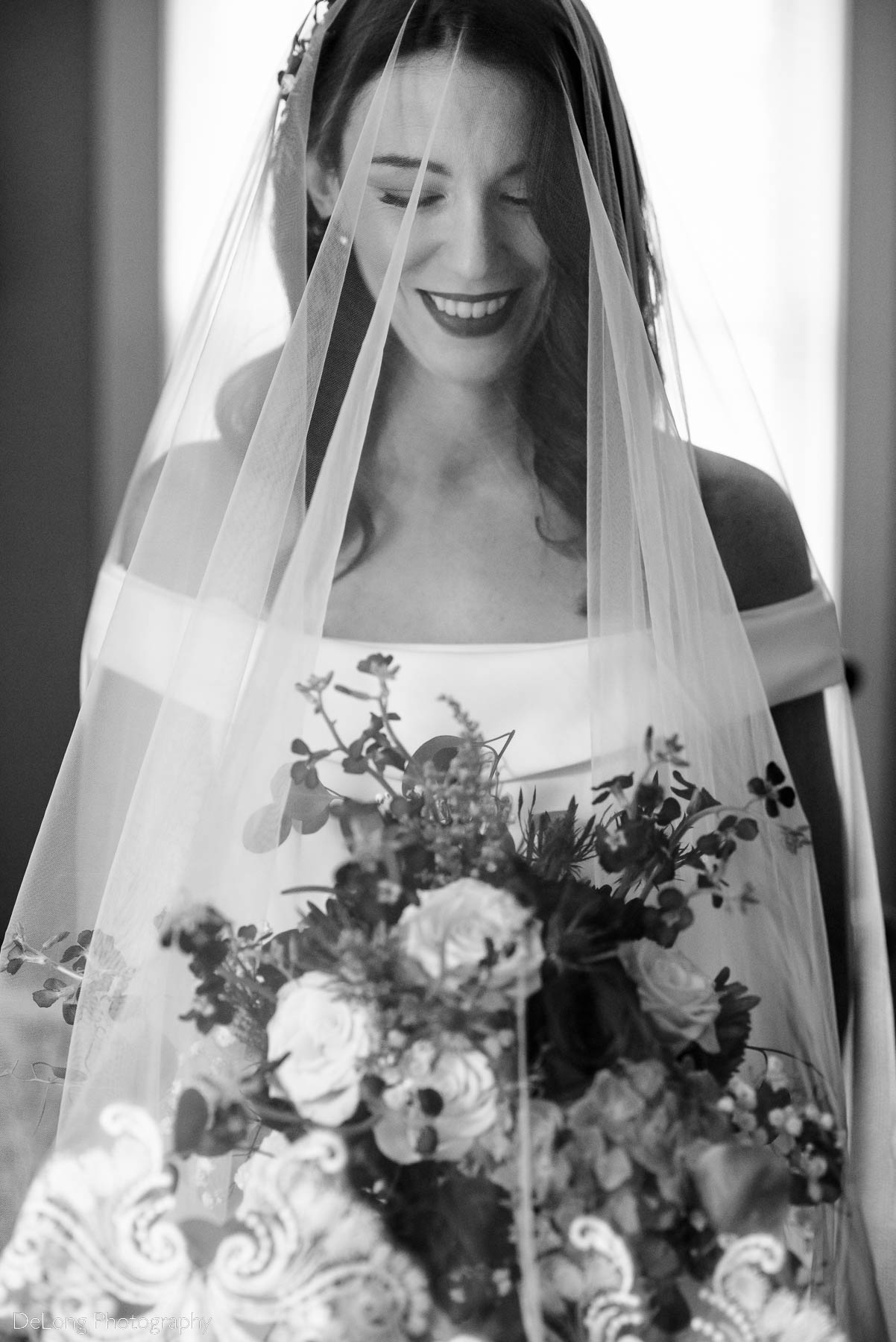 Black and white photograph of a bride with her veil draped over her face by Charlotte wedding photographers DeLong Photography