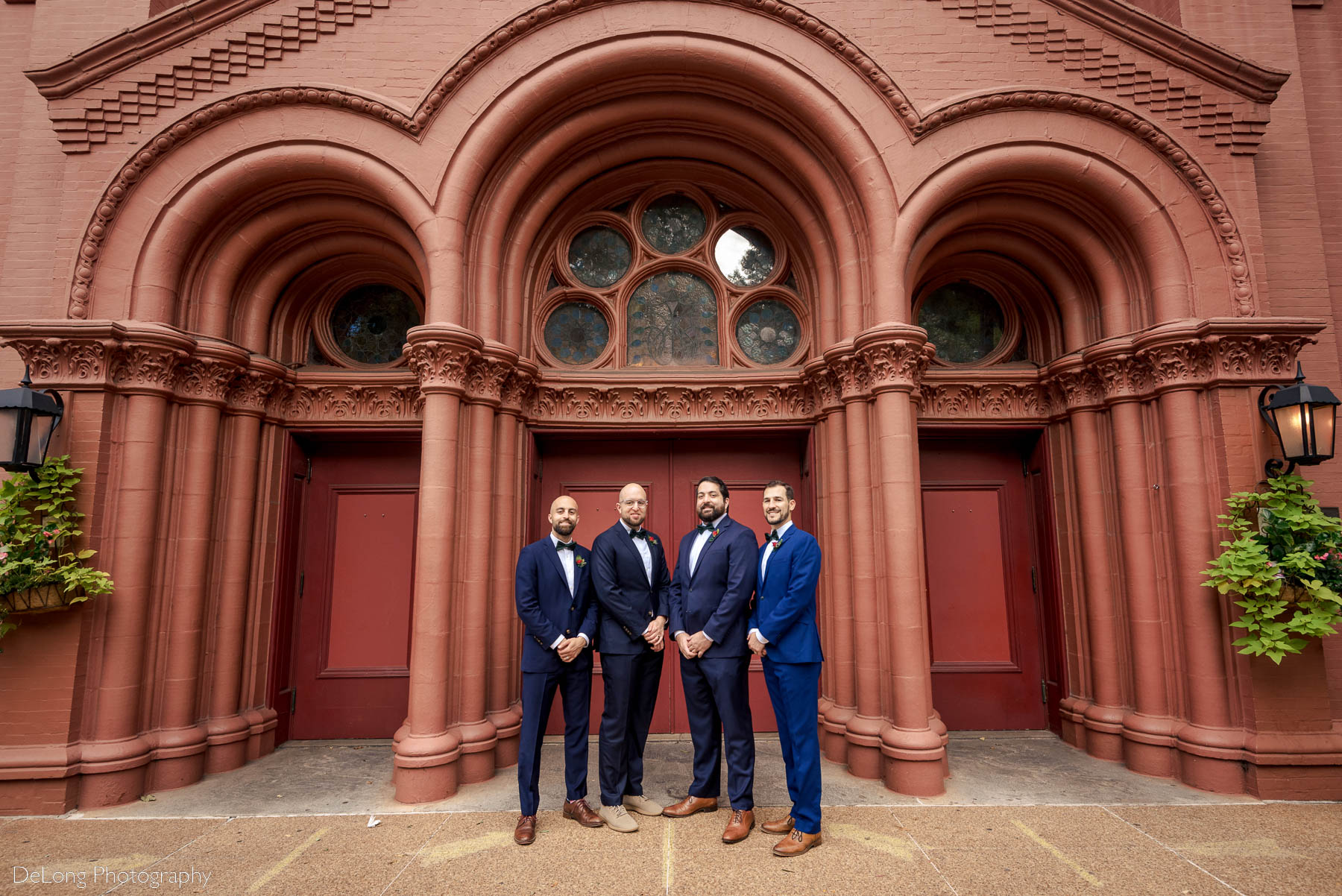 Formal portrait of groom with his groomsmen in front of the beautifully detailed doorway of the Basilica of the Sacred Heart of Jesus in Atlanta, GA by Charlotte wedding photographers DeLong Photography 