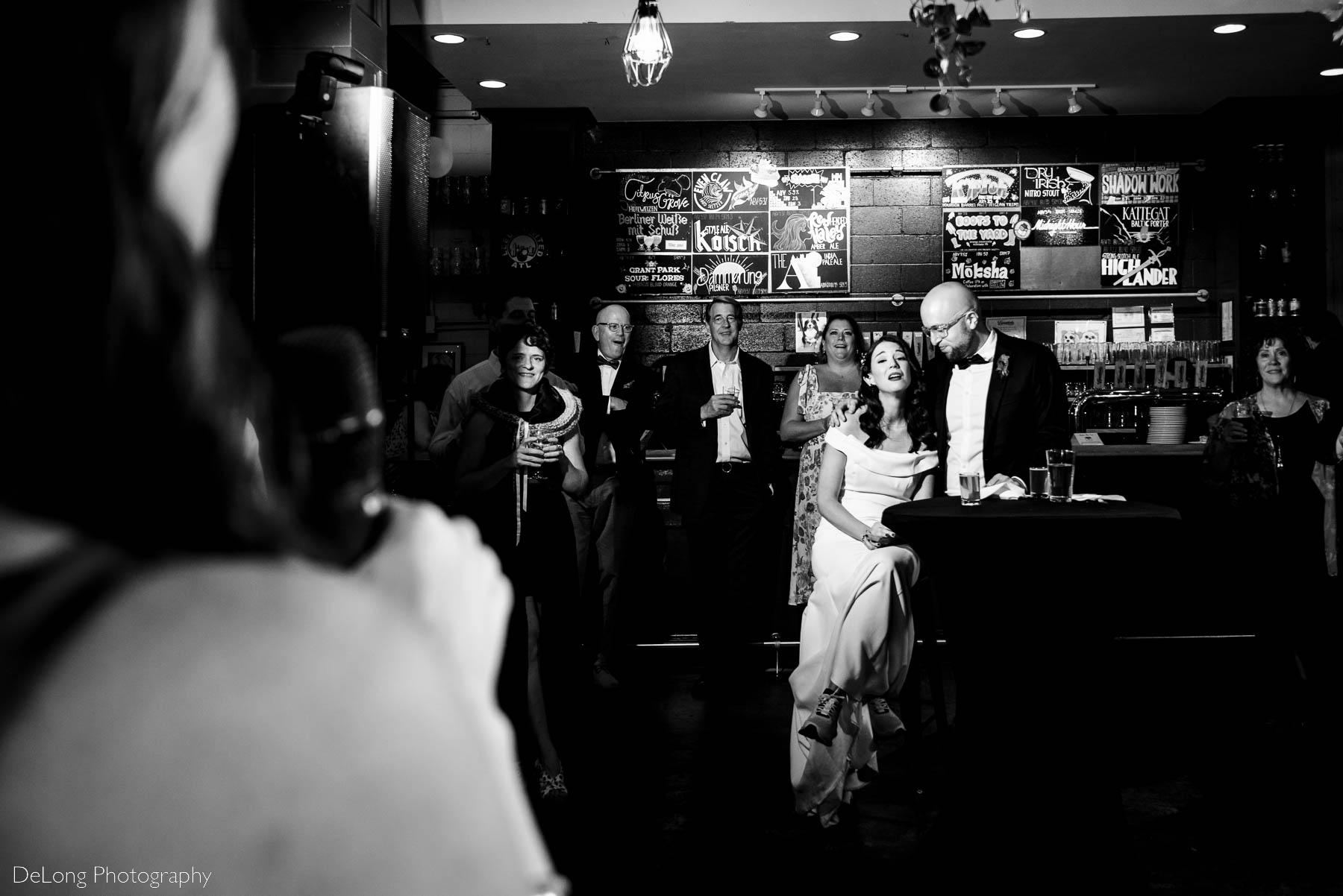 Black and white photograph of bride's reaction during toasts at Eventide Brewing in Atlanta, GA by Charlotte wedding Photographers DeLong Photography