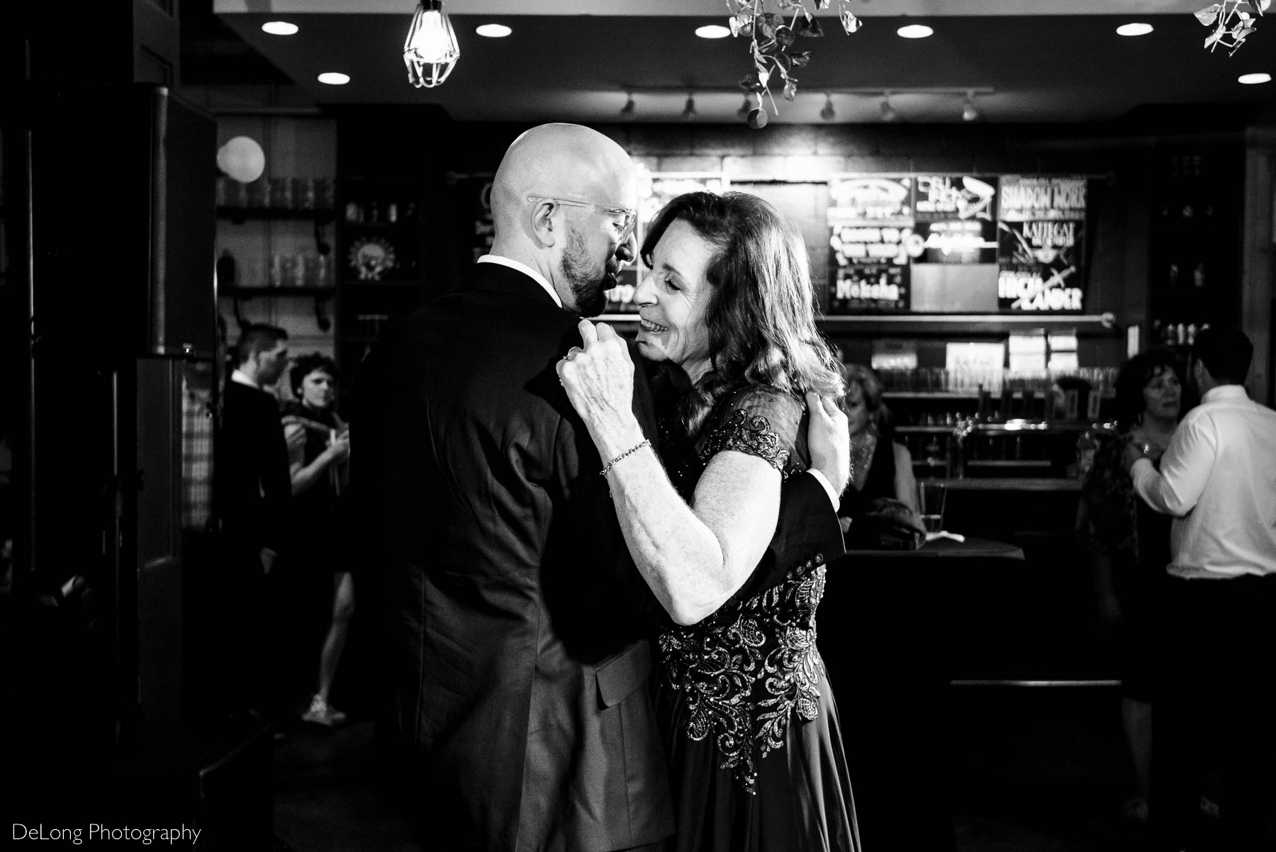 Black and white photograph of smiling mother during her mother-son dance at Eventide Brewing in Atlanta, GA by Charlotte wedding Photographers DeLong Photography