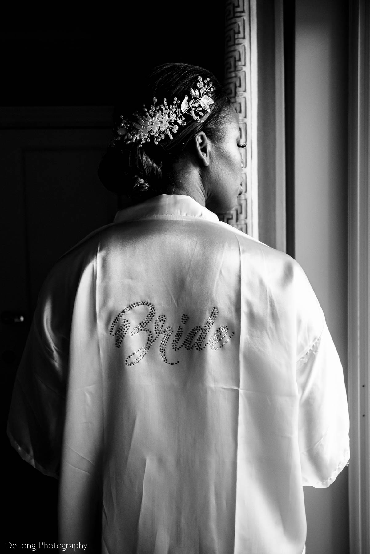 Black and white photograph highlighting the bride's embellished robe and hair piece taken as she was getting ready at the Ballantyne Hotel by Charlotte wedding photographers DeLong Photography