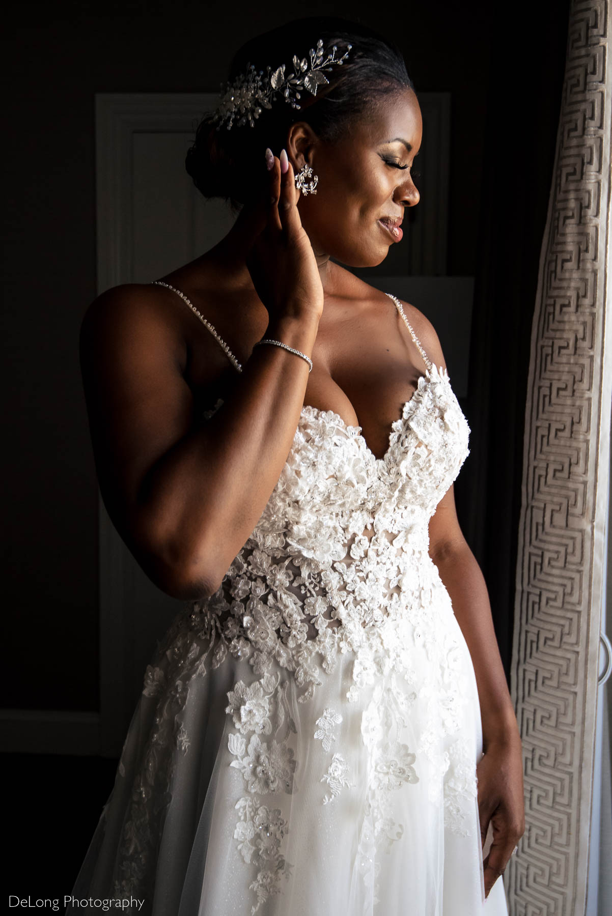 A portrait of the bride showcasing her hair piece, earrings and the appliqués on the bodice of her wedding dress at the Ballantyne Hotel by Charlotte wedding photographers DeLong Photography