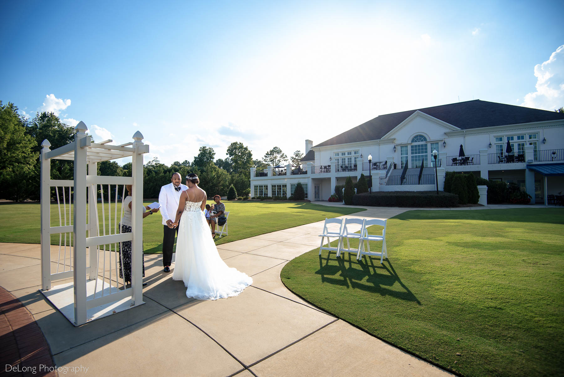 A wide angle perspective of an elopement ceremony facing into the club building at Providence Country Club by Charlotte wedding photographers DeLong Photography