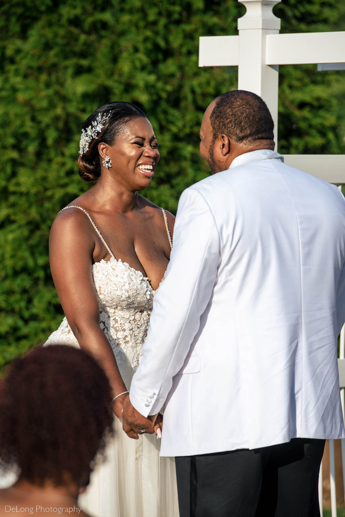 The bride giggling and smiling with her groom during their wedding ceremony at Providence Country Club by Charlotte wedding photographers DeLong Photography