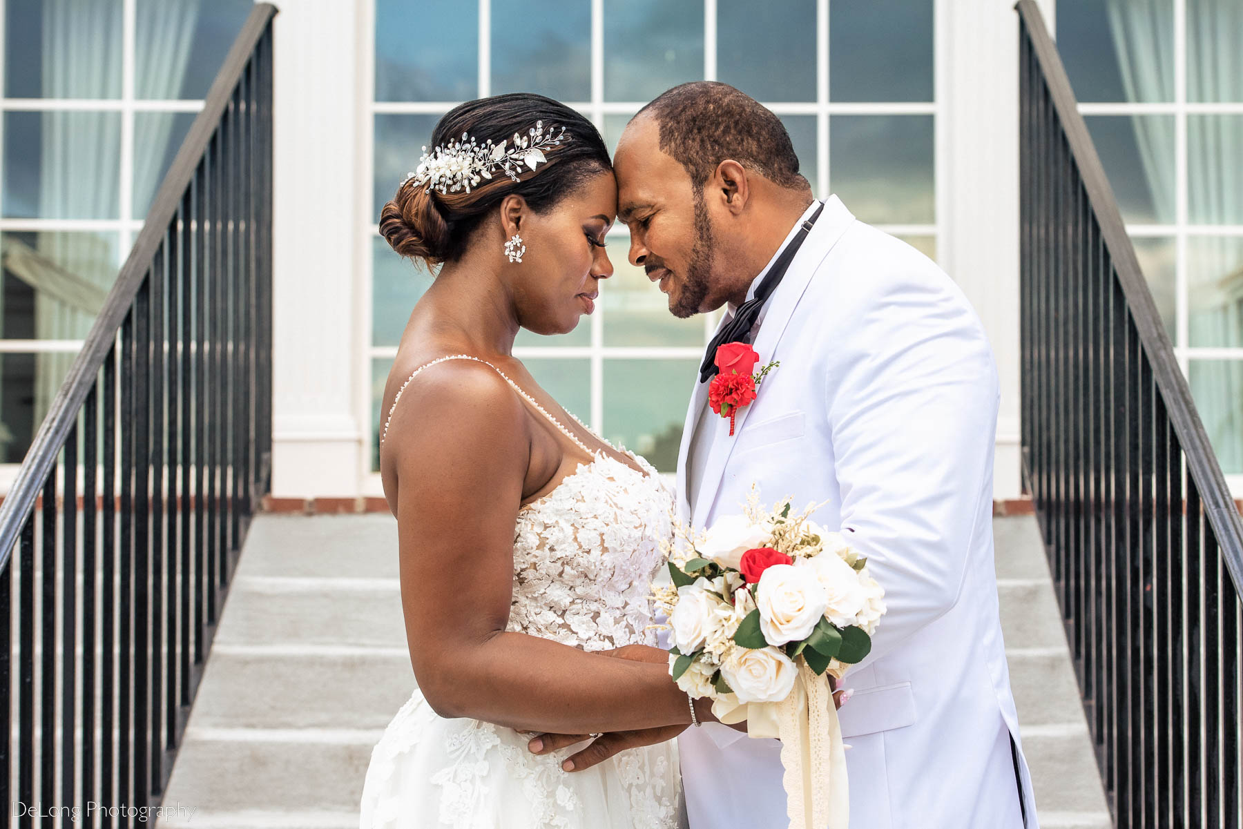 A sweet photograph of the bride and groom with their heads together on the steps at Providence Country Club by Charlotte wedding photographers DeLong Photography