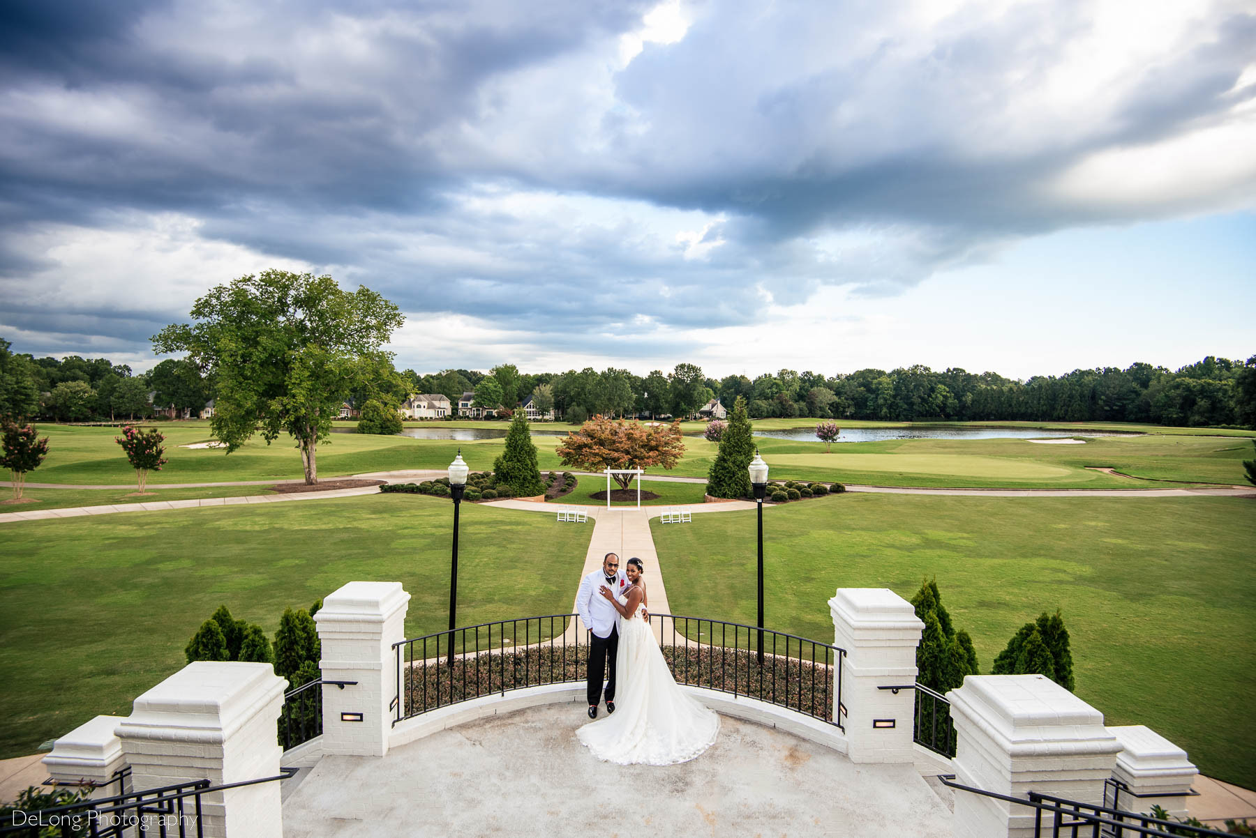 A wide and high perspective portrait of the bride and groom showcasing the beautiful scenery of the gold course at Providence Country Club by Charlotte wedding photographers DeLong Photography