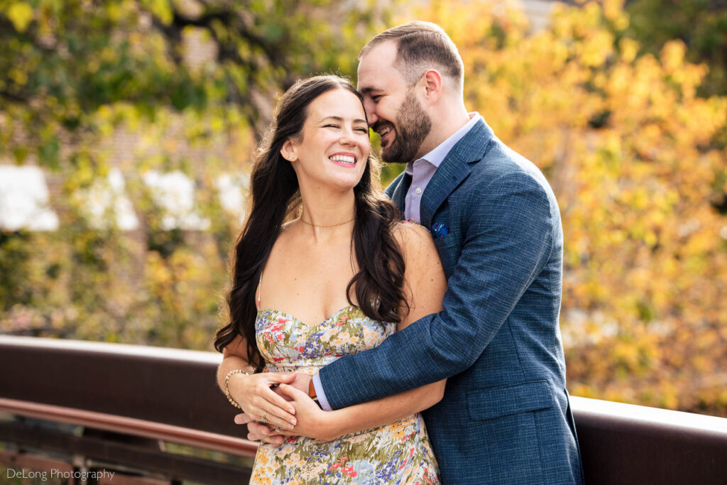 Engaged couple giggling in front of yellow fall foliage at Westside Provisions in Atlanta by Charlotte Wedding Photographers DeLong Photography