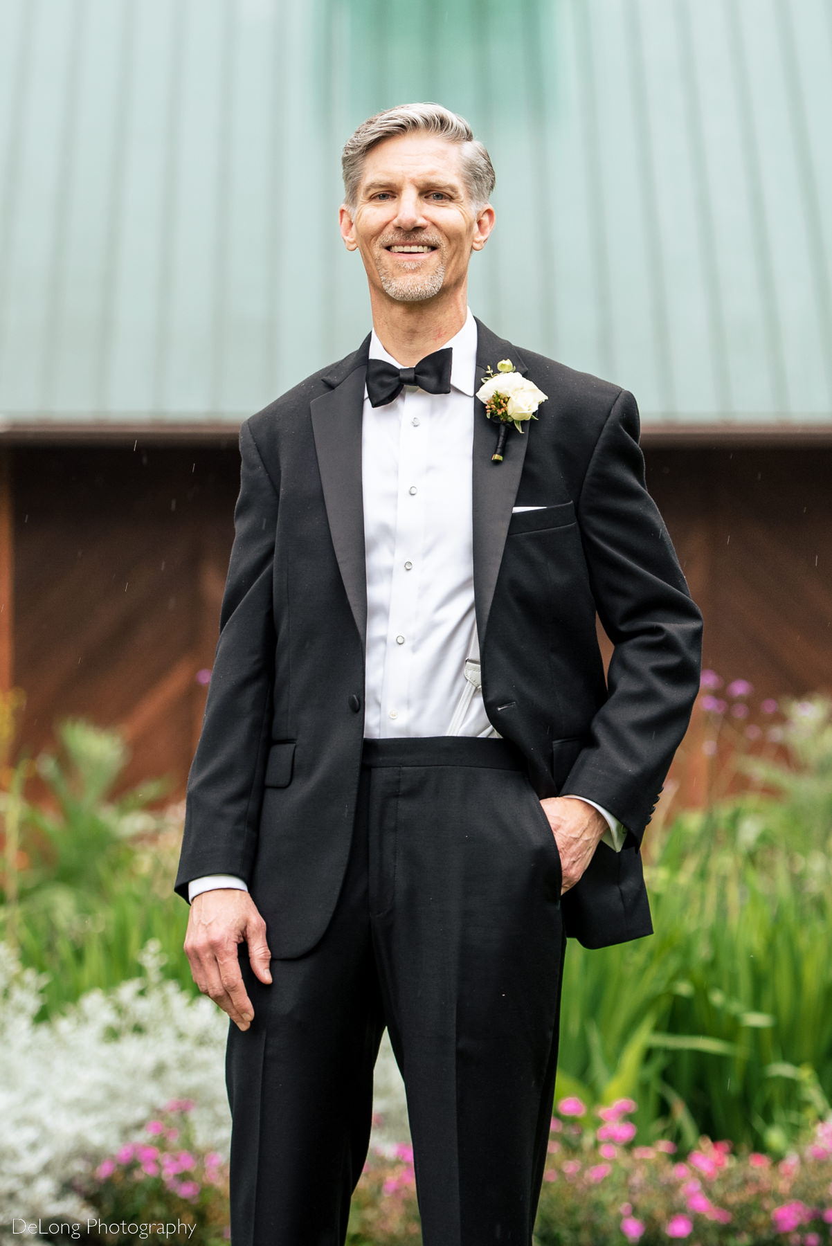 Groom portrait outside in the garden of Alexander Homestead. Photograph by Charlotte wedding photographers DeLong Photography.