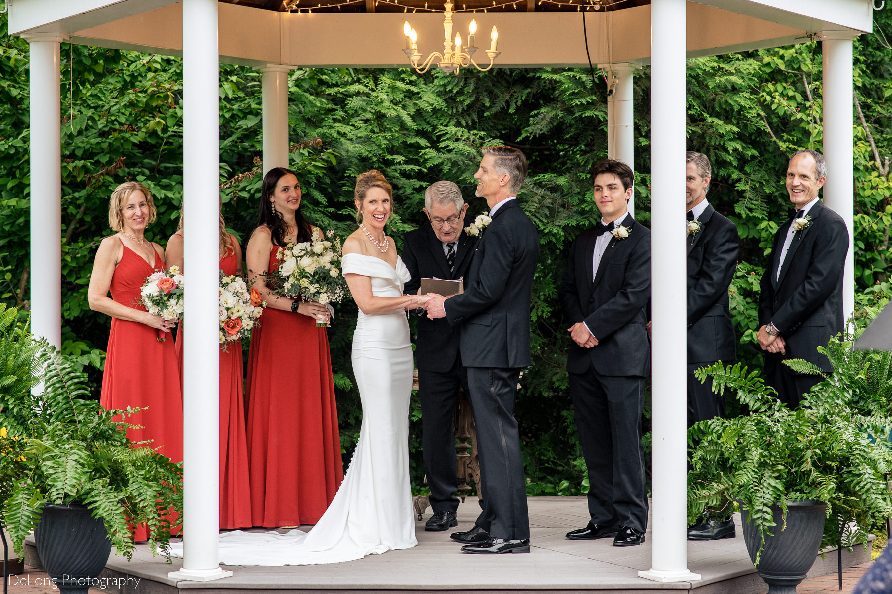 Candid photograph of a bride laughing during her wedding ceremony at Alexander Homestead. Photograph by Charlotte wedding photographers DeLong Photography.