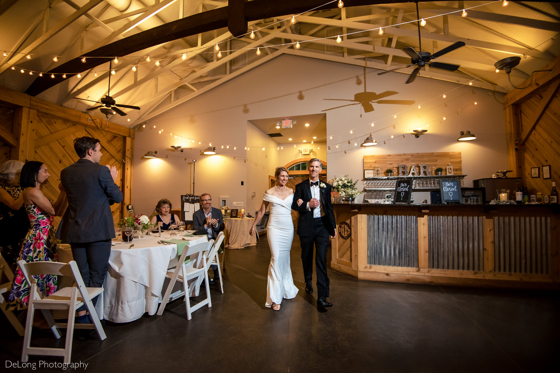 Bride and groom entering their reception smiling at Alexander Homestead. Photograph by Charlotte wedding photographers DeLong Photography.