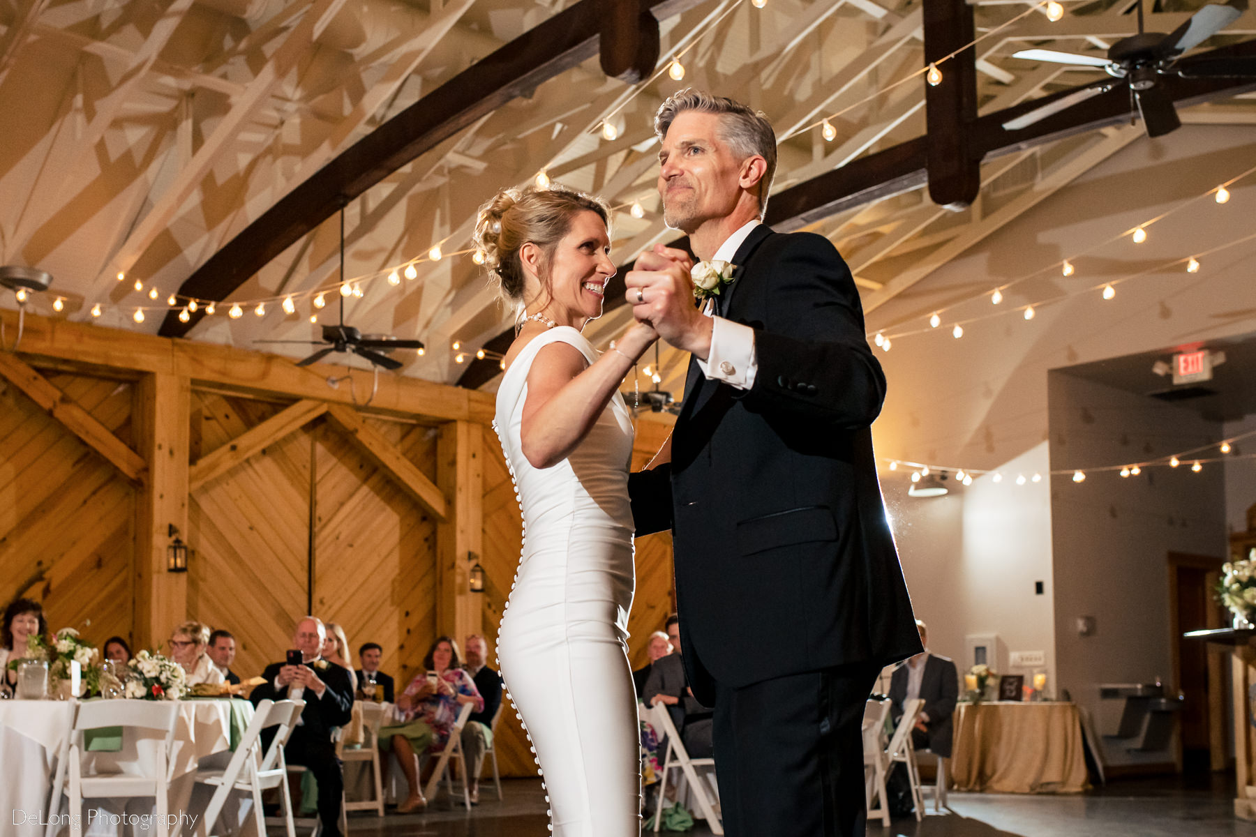 Bride and groom smiling during their first dance at Alexander Homestead. Photograph by Charlotte wedding photographers DeLong Photography.