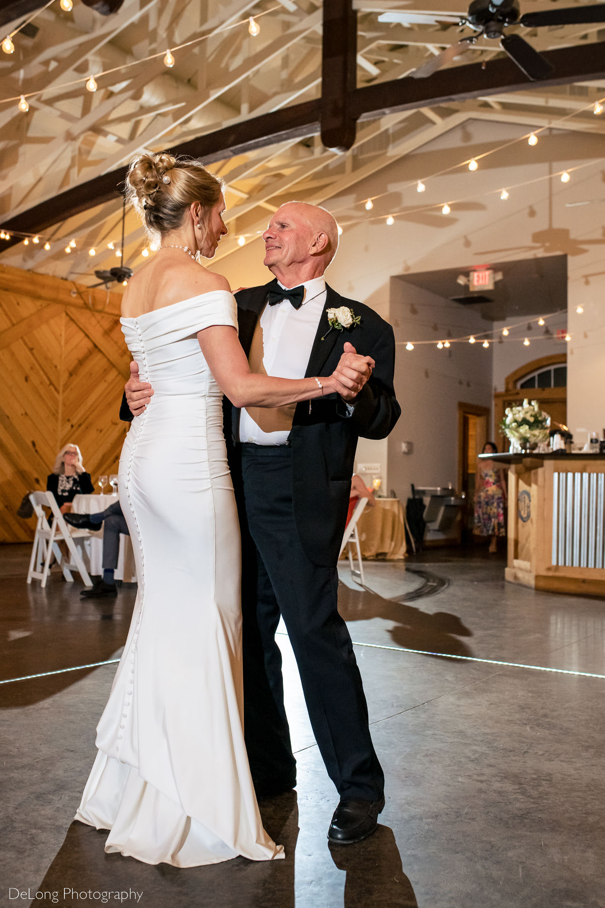 Father of the bride smiling at his daughter during the father-daughter dance at Alexander Homestead. Photograph by Charlotte wedding photographers DeLong Photography.