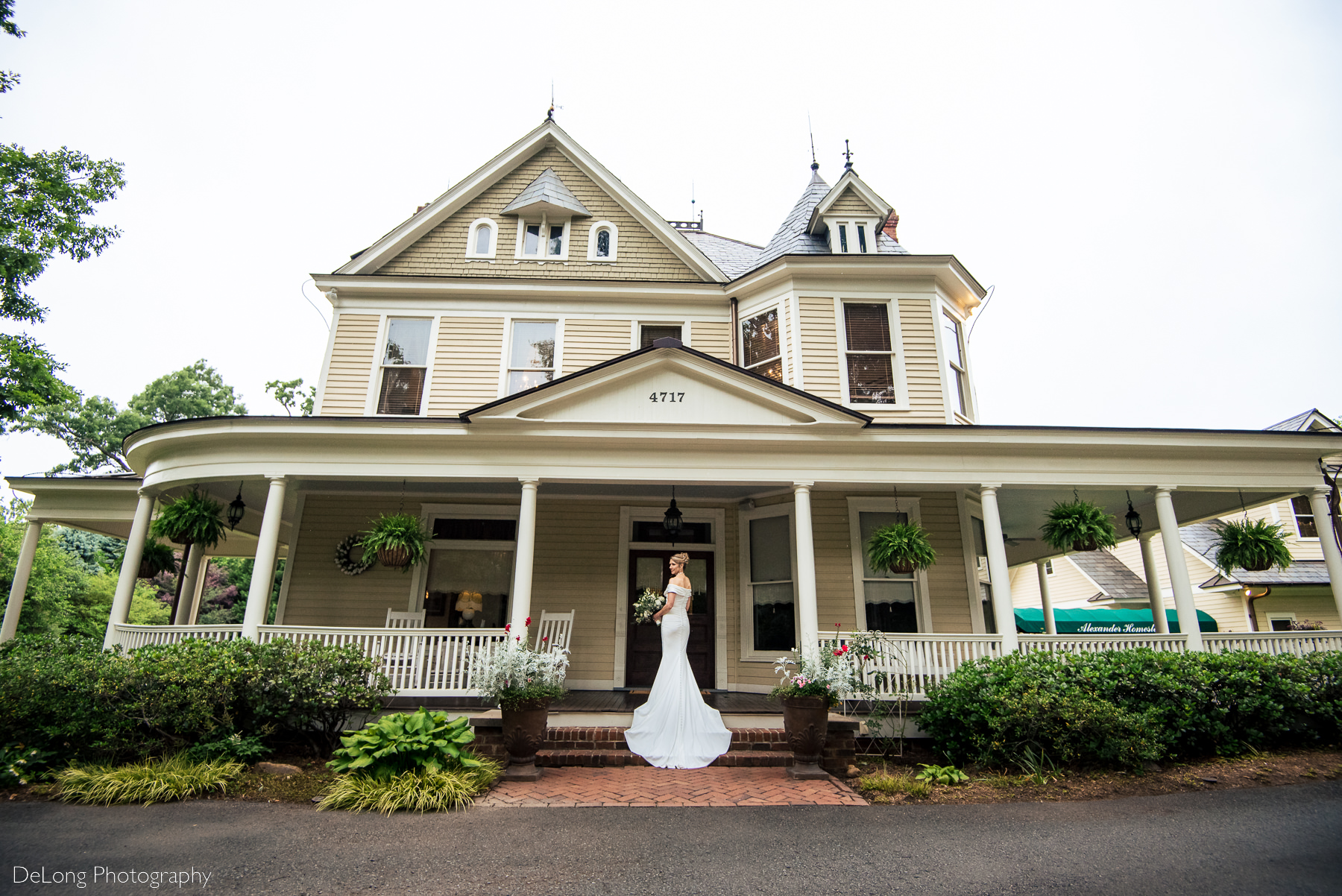 Bridal portrait on porch of Alexander Homestead on a rainy day. Photograph by Charlotte wedding photographers DeLong Photography.