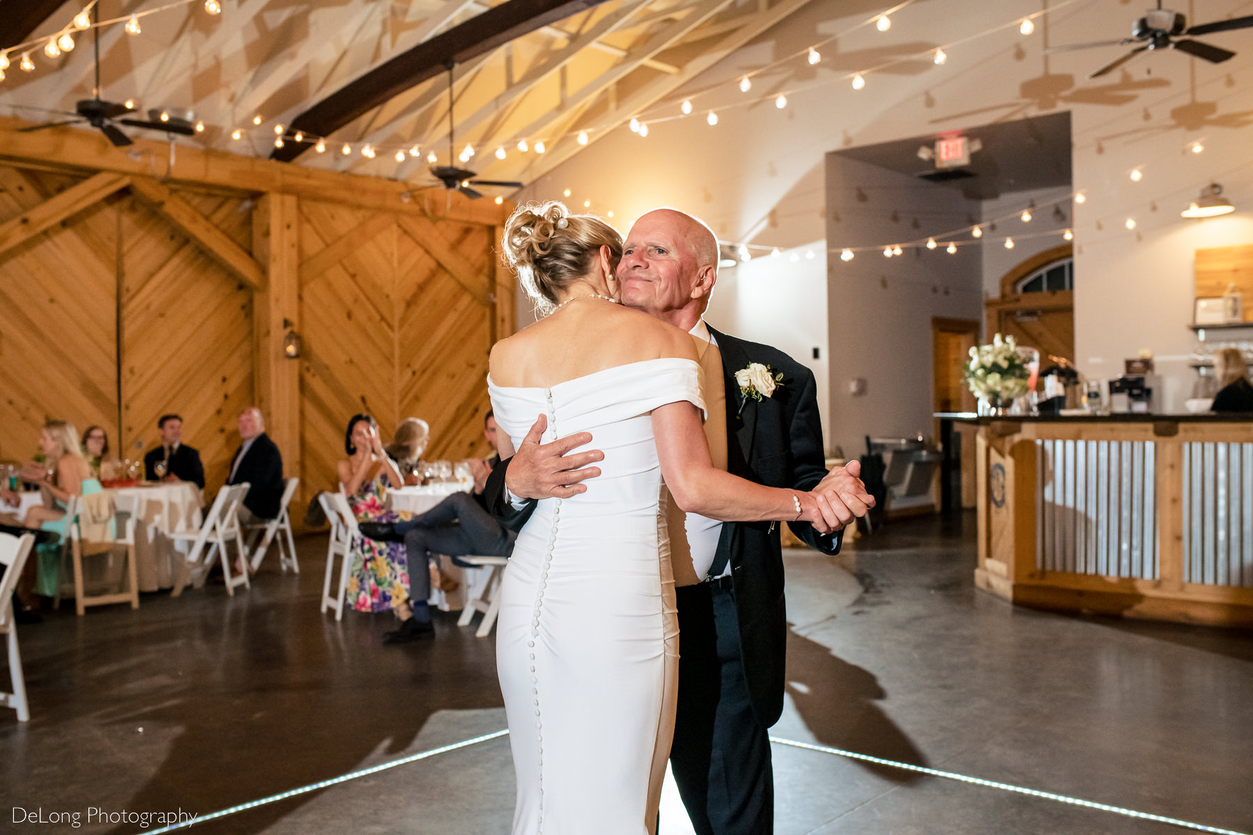 Father hugging his bride during the father-daughter dance at Alexander Homestead. Photograph by Charlotte wedding photographers DeLong Photography.