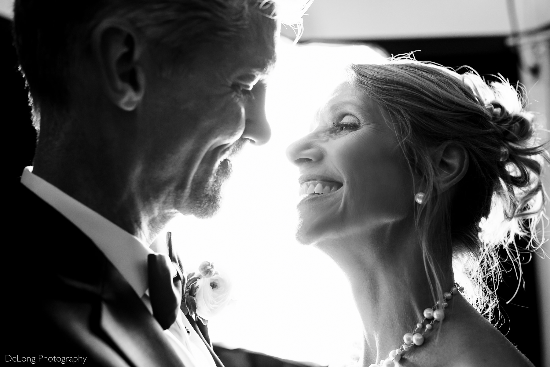 Up close black and white nighttime photograph of bride and groom smiling at one another at Alexander Homestead.