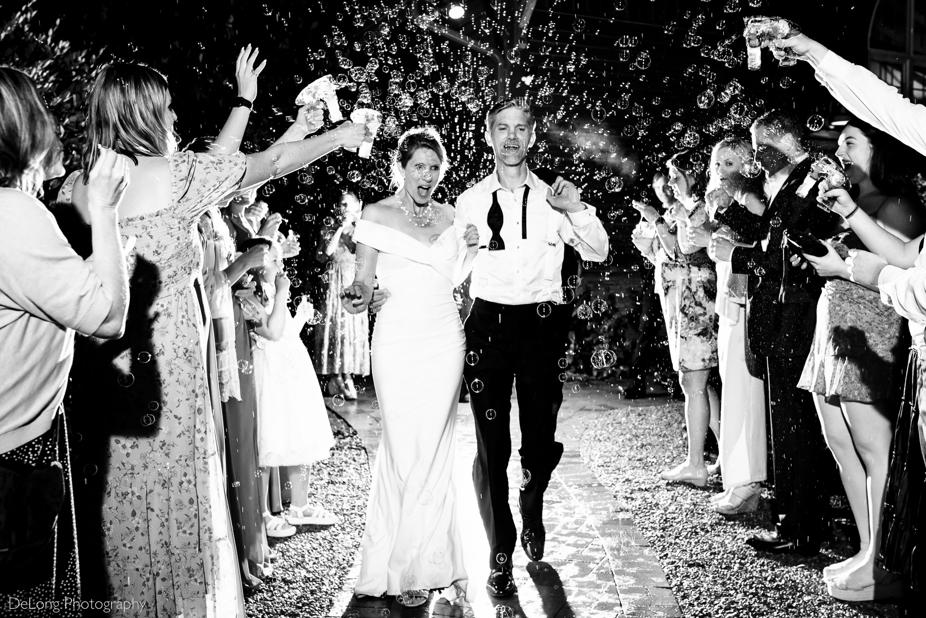 Black and white photograph of bride's look of surprise during the bubble exit at Alexander Homestead. Black and white nighttime silhouette of a couple with their foreheads together, standing inside the gazebo at Alexander Homestead. Photo by Charlotte wedding photographers DeLong Photography.