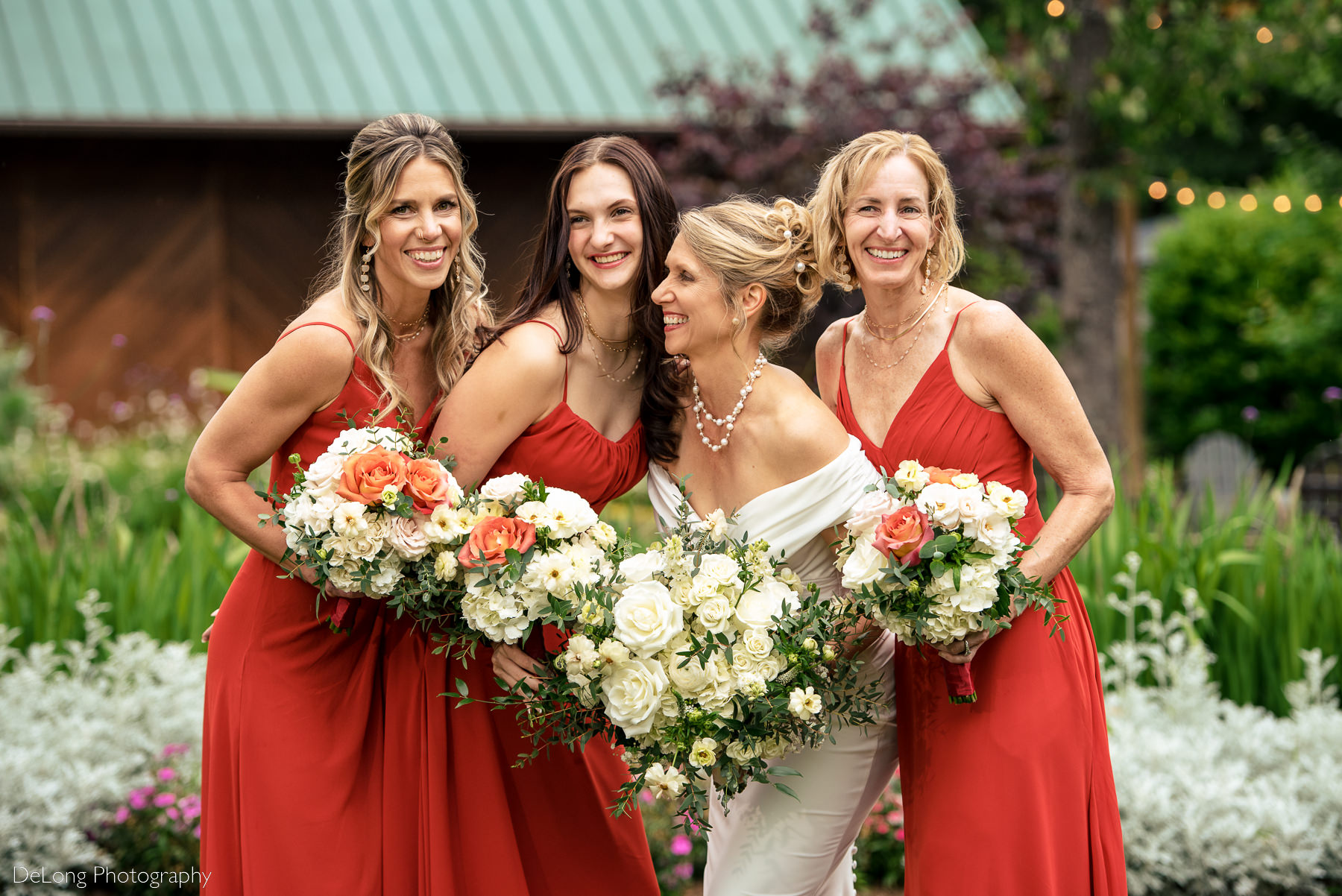 Bride laughing with her bridesmaids. Bridesmaid color palette is burnt orange. Photograph by Charlotte wedding photographers DeLong Photography.