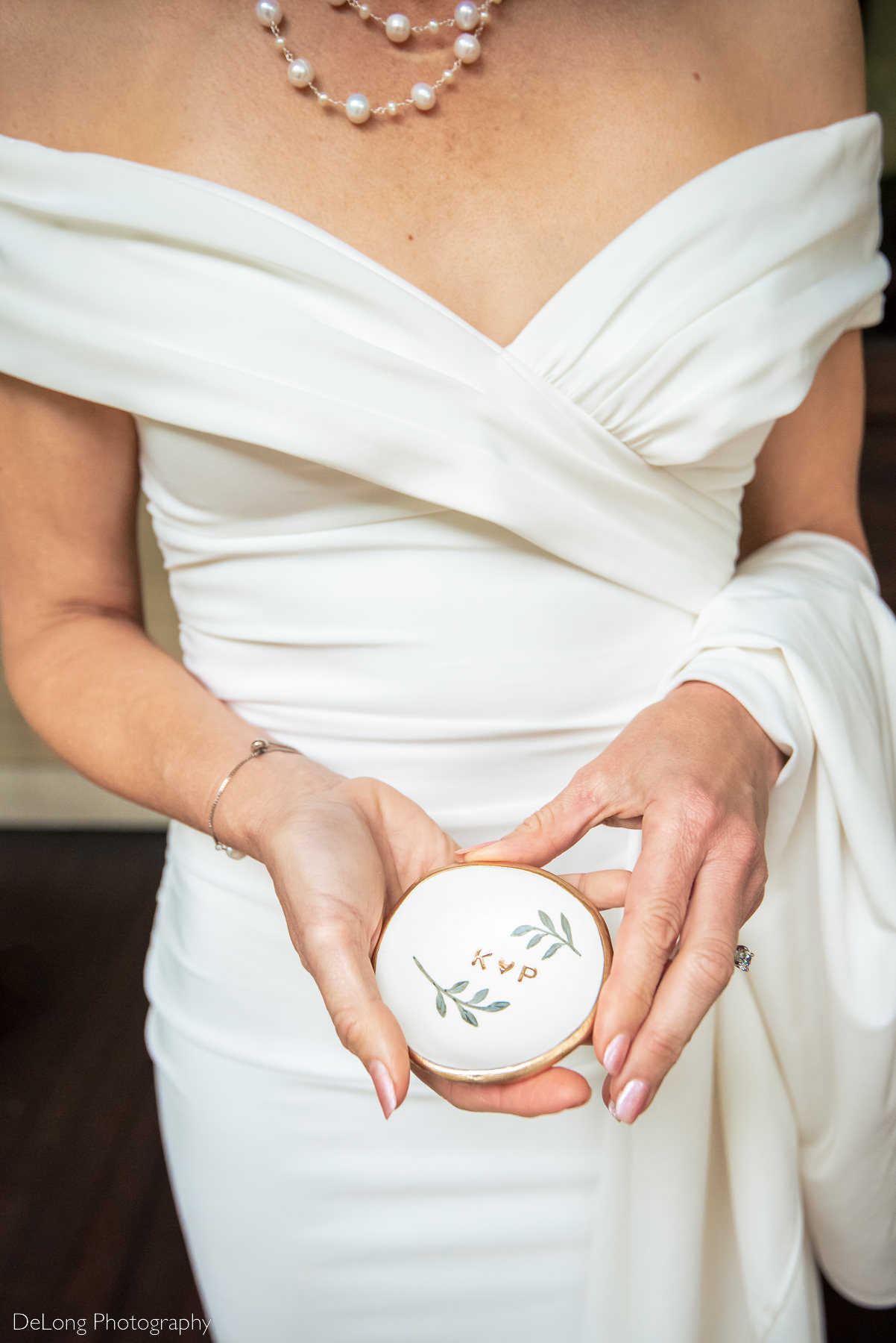 Jewelry dish wedding gift groom gave to his bride. Bride is holding it in her hands. Photograph by Charlotte wedding photographers DeLong Photography.