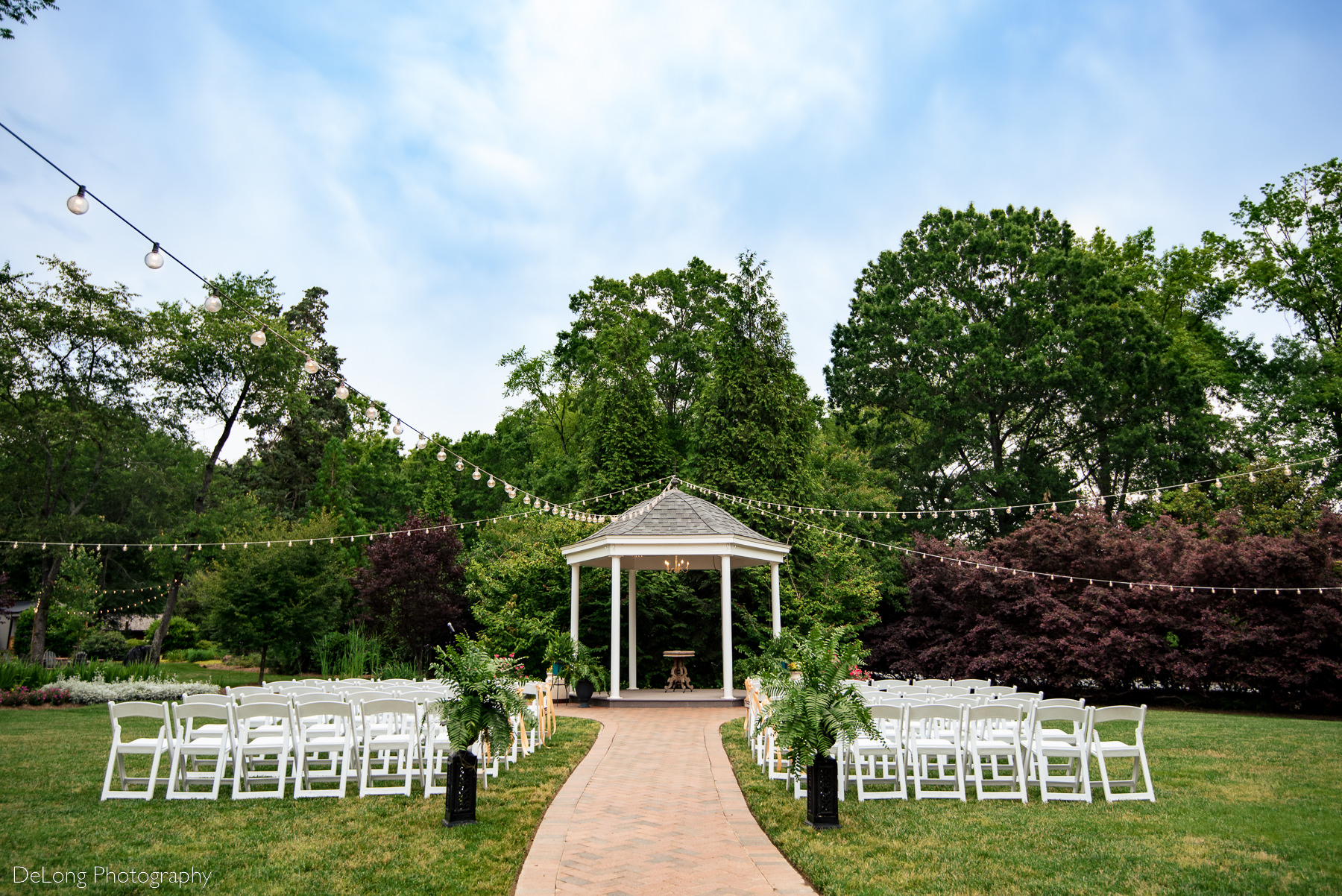 Outdoor wedding ceremony set up at the gazebo of Alexander Homestead. Photograph by Charlotte wedding photographers DeLong Photography.