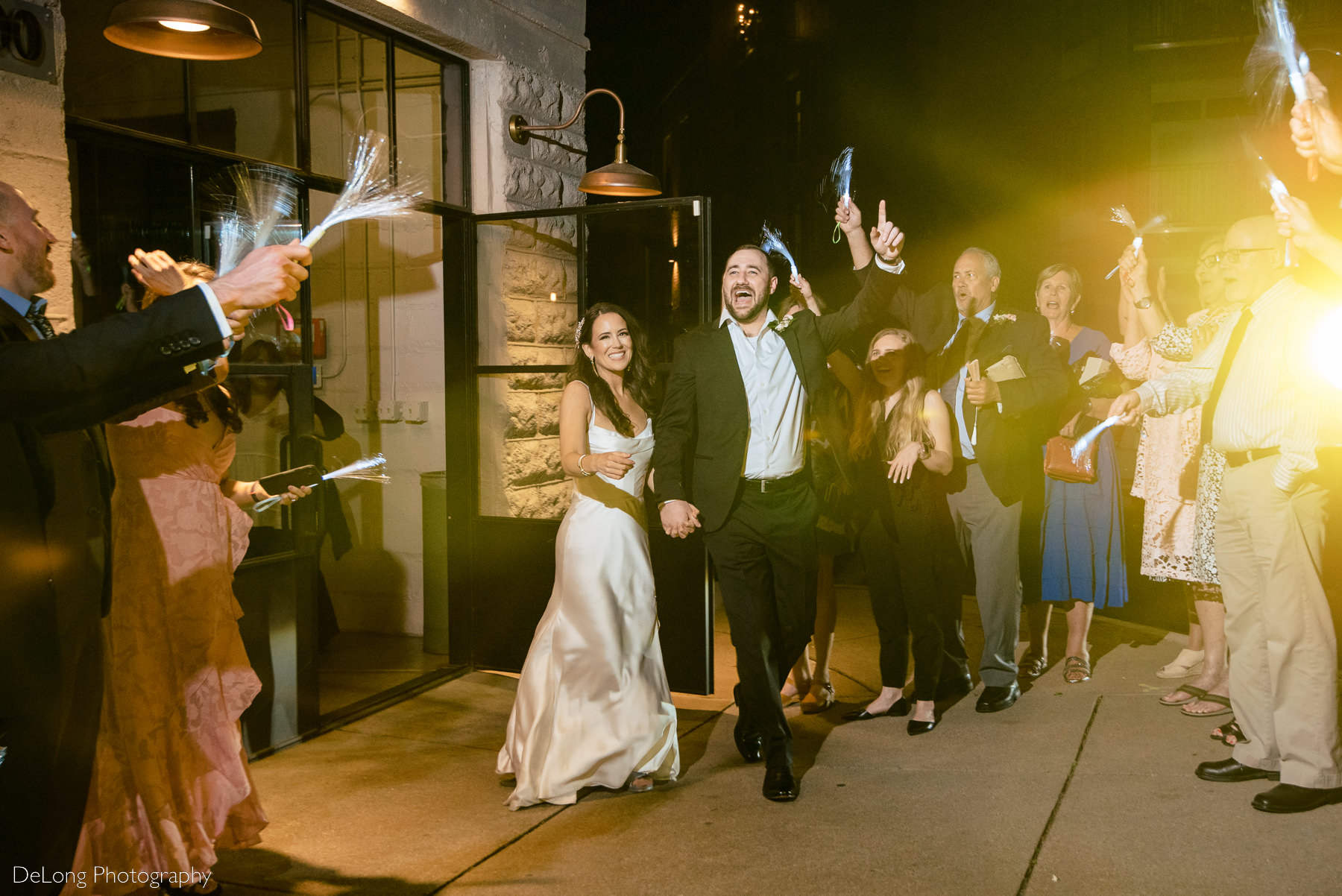 Bride and groom exiting their wedding reception at the end of the night at Upstairs Atlanta. Photograph by Charlotte wedding photographers DeLong Photography.