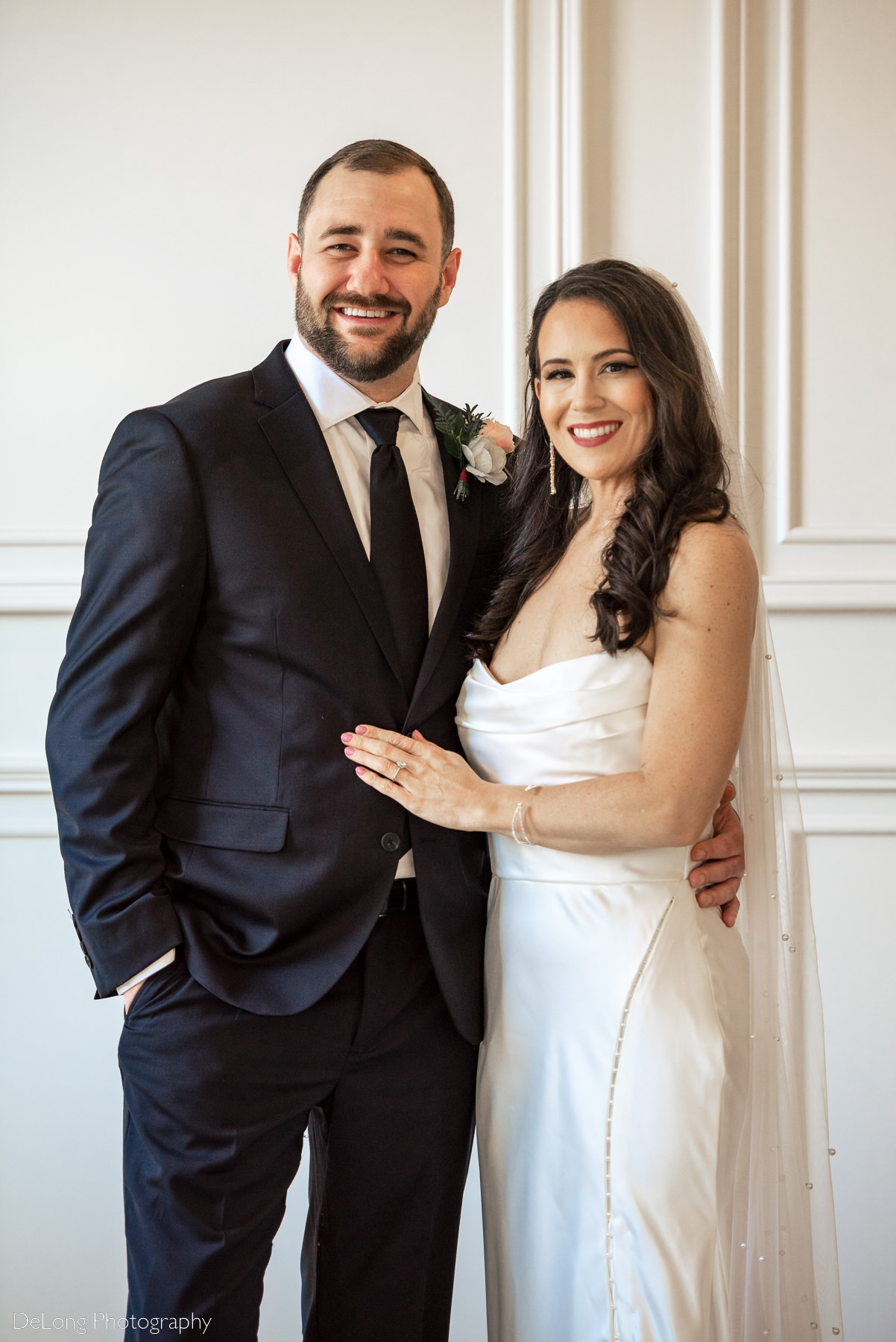 Bride and groom posing for a traditional photograph, smiling directly at the camera inside Upstairs Atlanta. Photograph by Charlotte wedding photographers DeLong Photography.