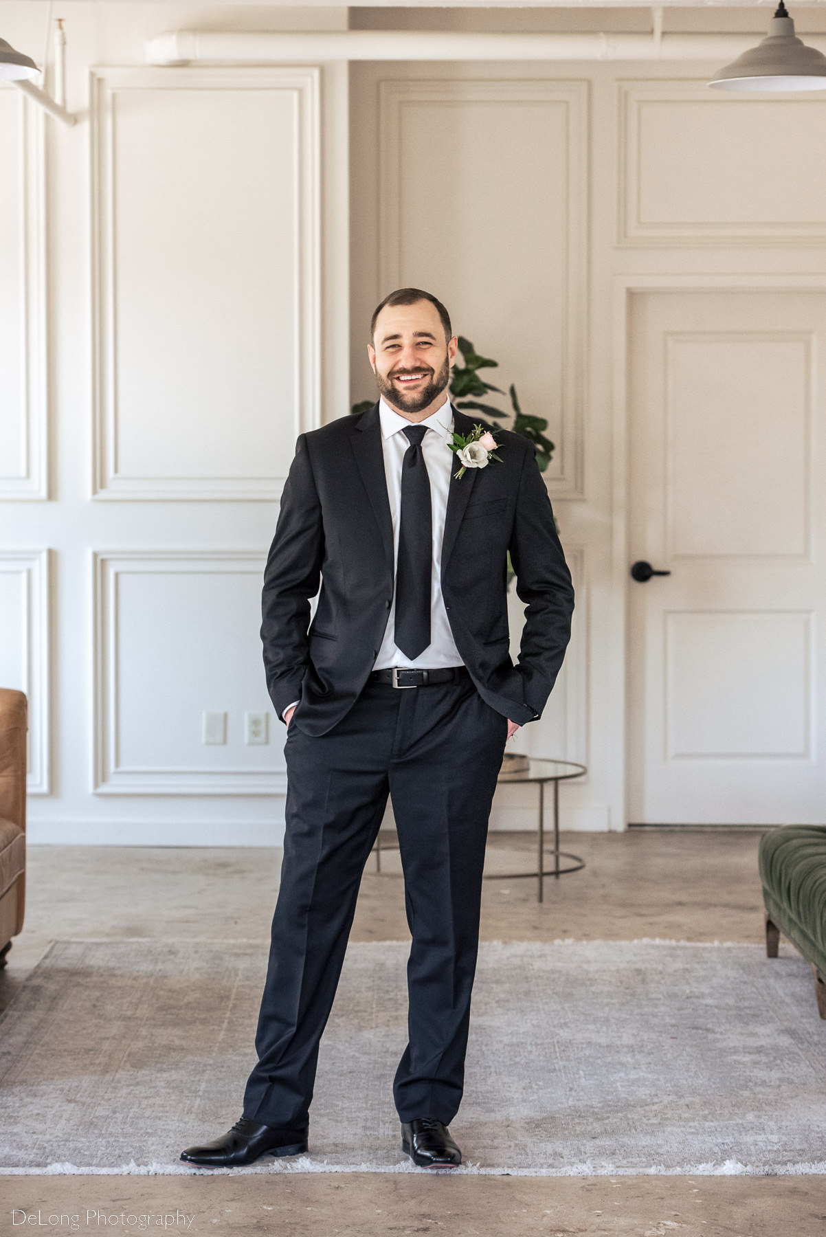 Traditional groom portrait where he is smiling directly at the camera, inside Upstairs Atlanta. Photograph by Charlotte wedding photographers DeLong Photography.