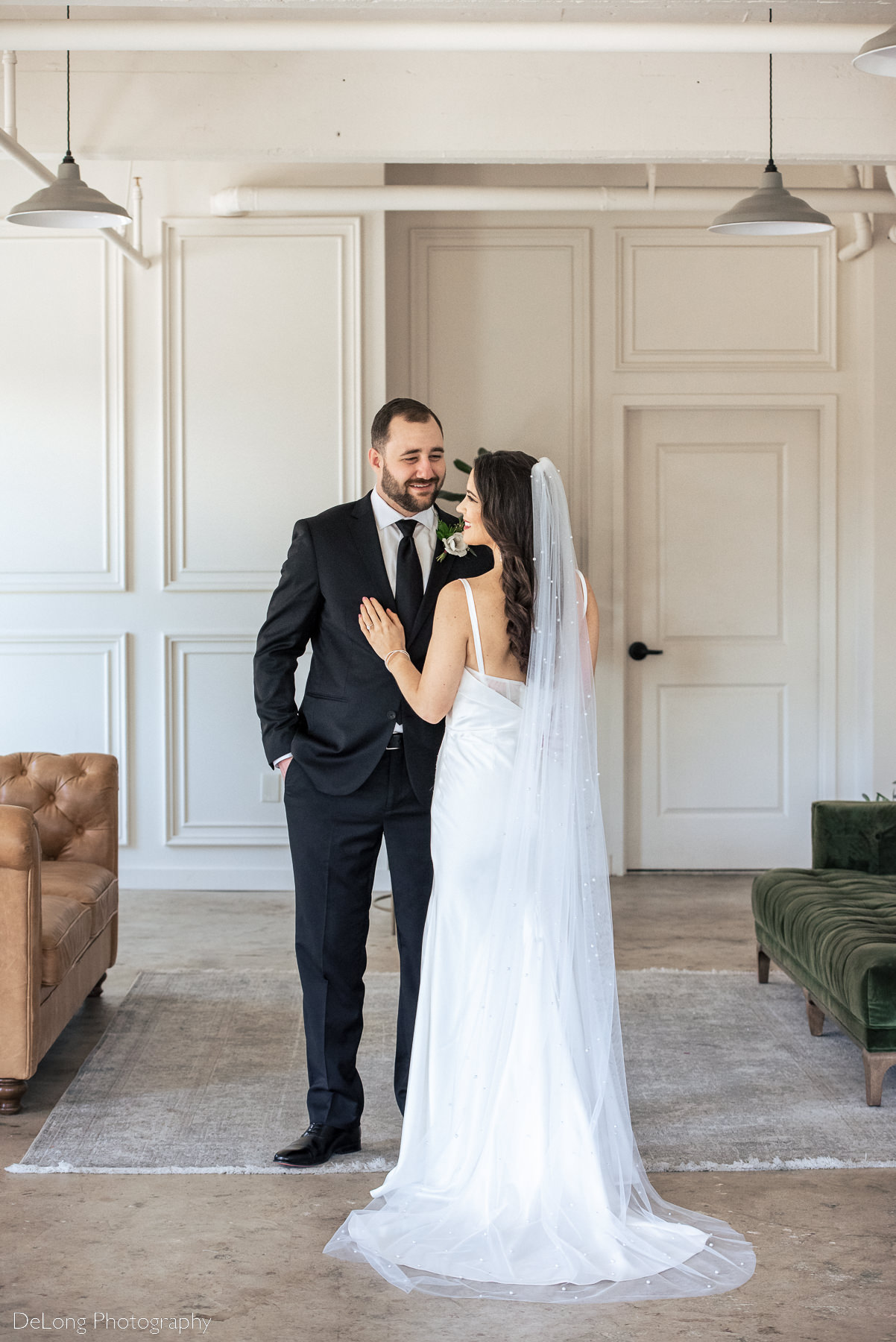 Portrait of bridge and groom inside Upstairs Atlanta. The bridge is looking over her left shoulder, an the groom is gazing at her smiling. Photograph by Charlotte wedding photographers DeLong Photography.