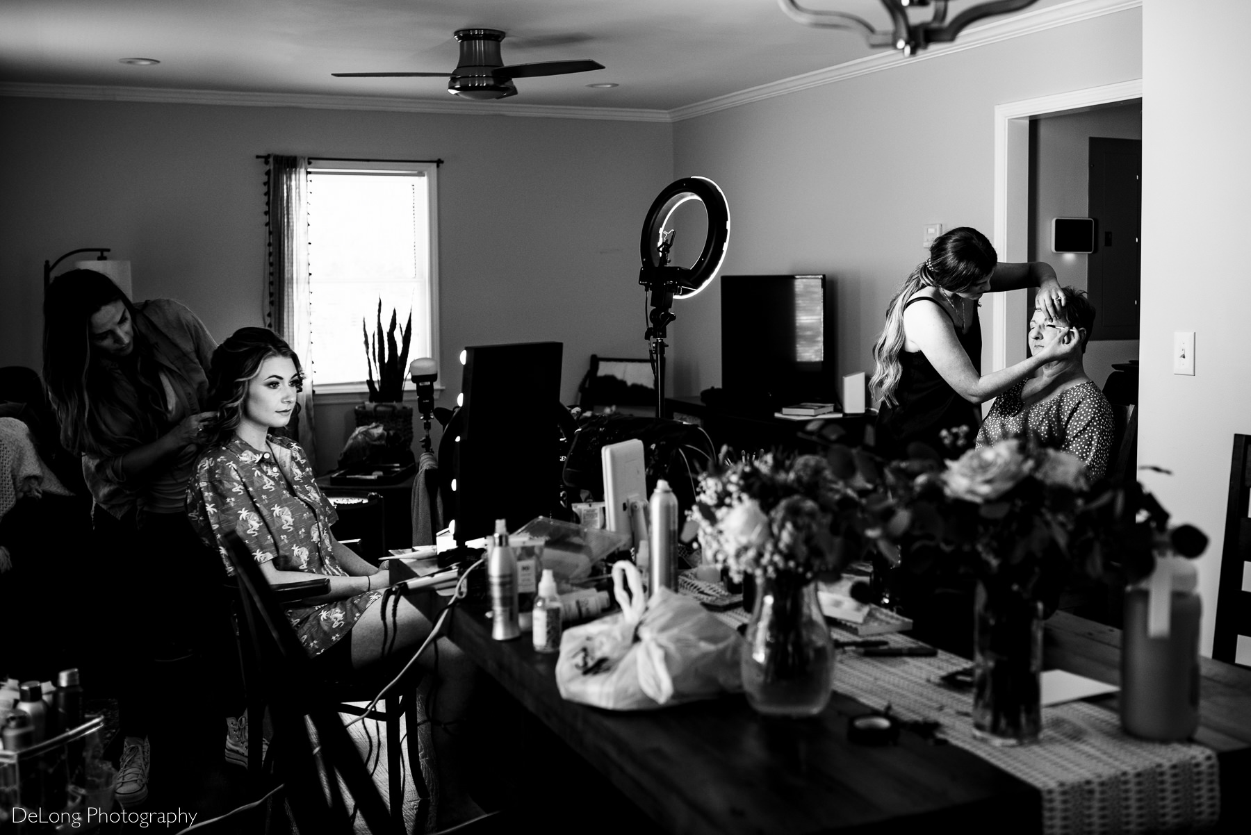 black and white photograph of bride's family getting ready in her living room by Charlotte wedding photographers DeLong Photography