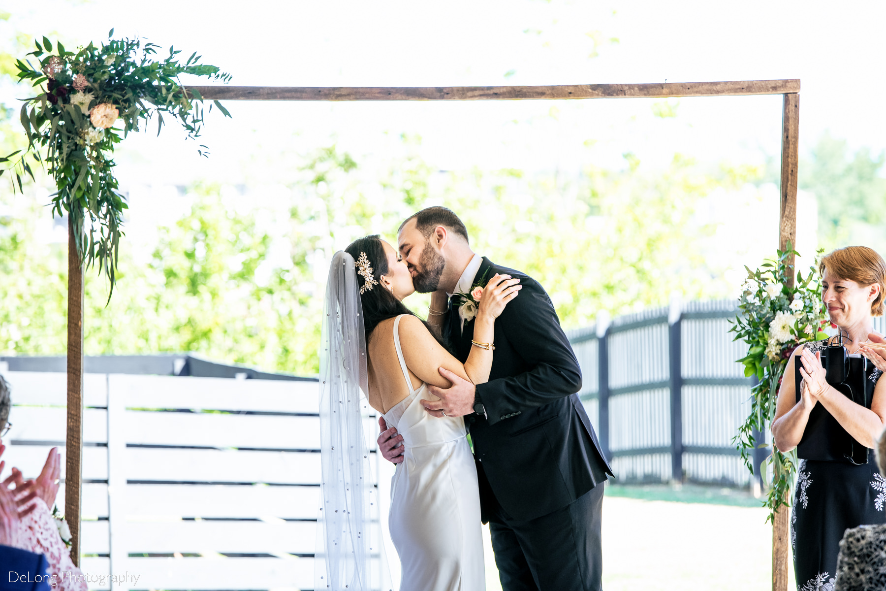 Bridge and groom first kiss at the conclusion of their wedding ceremony. Photograph by Charlotte wedding photographers DeLong Photography.