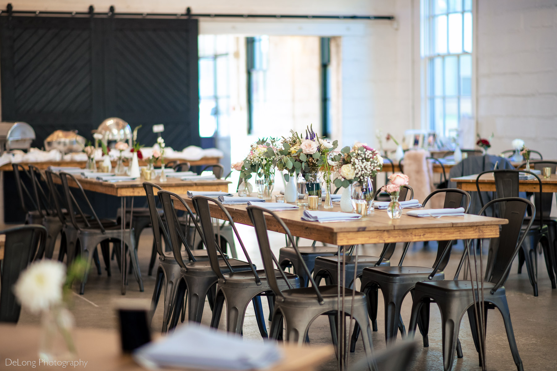 Photograph showcasing the spring floral arrangements in the wedding reception space of Upstairs Atlanta. Photograph by Charlotte wedding photographers DeLong Photography.