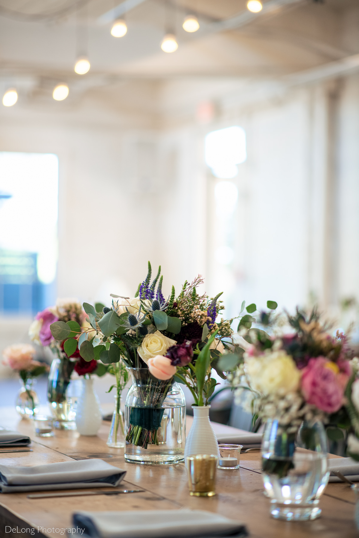 Up close photograph showcasing the spring floral centerpieces used on the tables of Upstairs Atlanta. Photograph by Charlotte wedding photographers DeLong Photography.