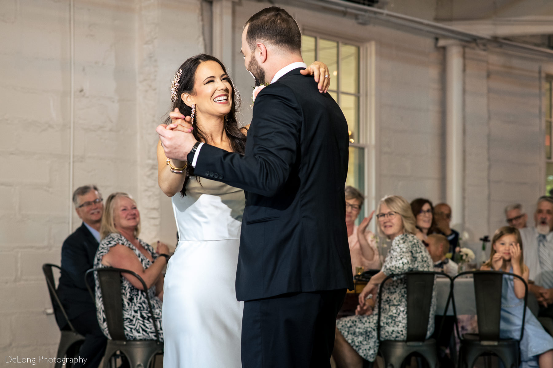 Bride laughing and enjoying her first dance with her groom at Upstairs Atlanta. Photograph by Charlotte wedding photographers DeLong Photography.