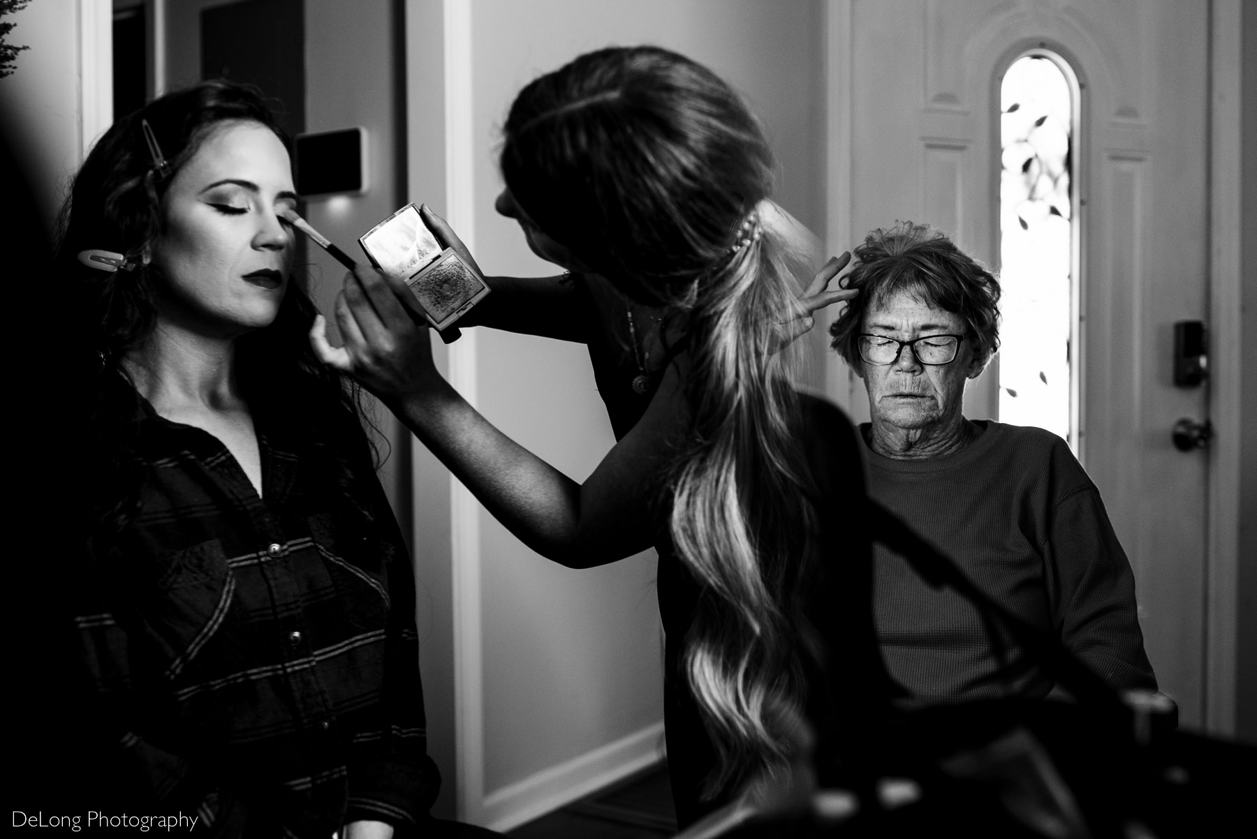 black and white photograph of bride and her mother getting ready in the same image by Charlotte wedding photographers DeLong Photography