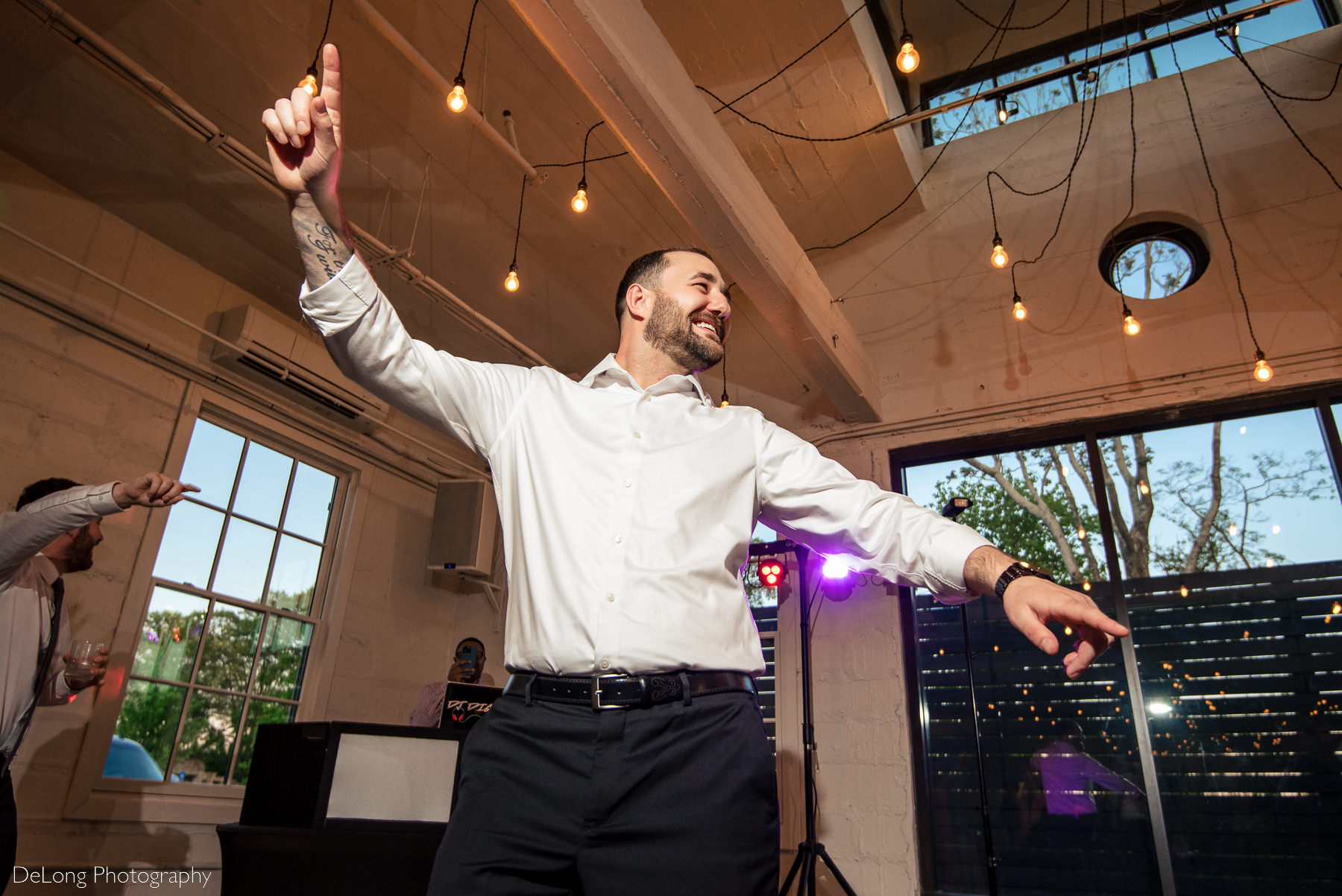 Low angle photograph of groom dancing and having fun on the dance floor of Upstairs Atlanta. Photograph by Charlotte wedding photographers DeLong Photography.