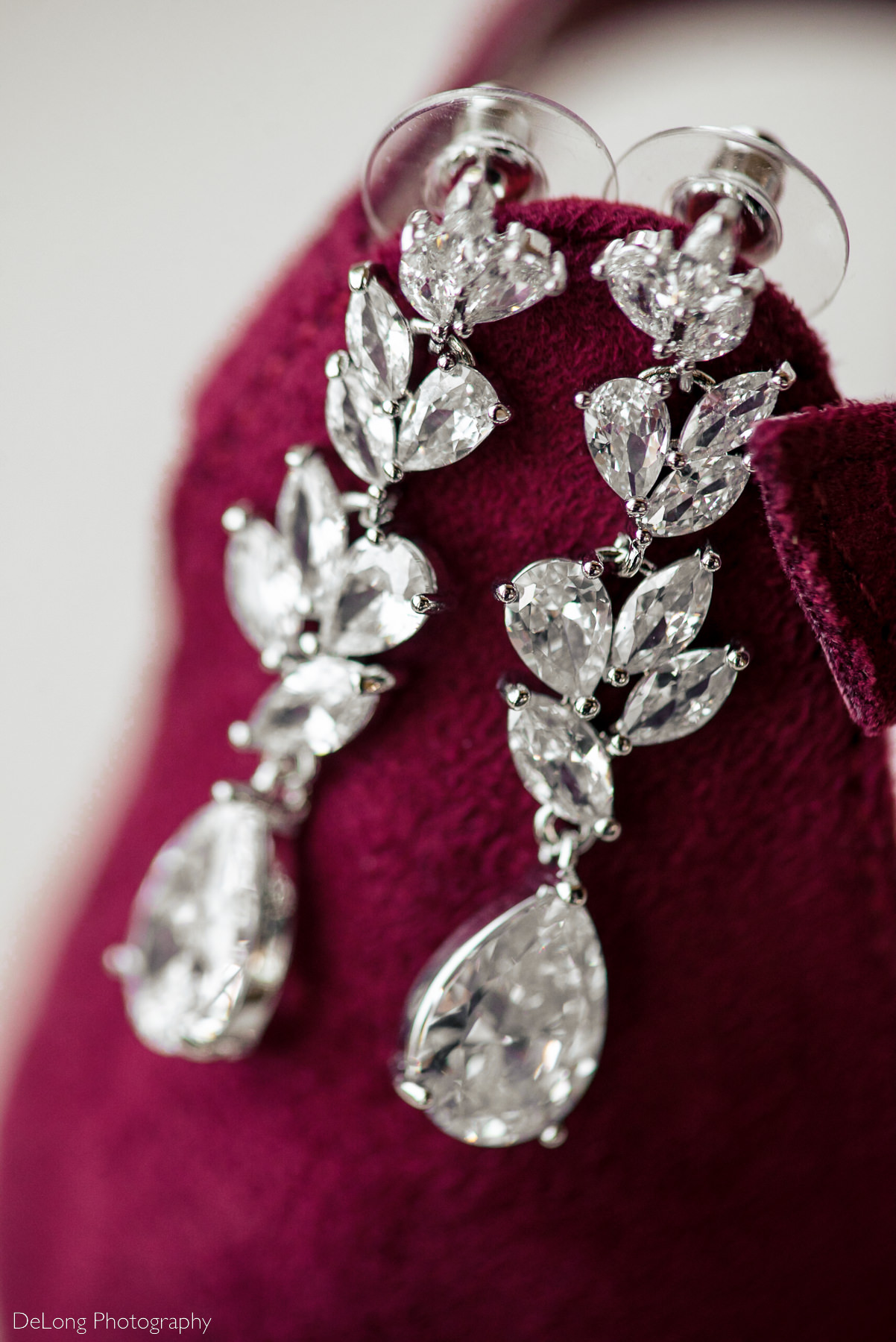 Macro photograph of bridal earrings featuring pear and marquis shaped clear stones at Pine Island Country Club in Charlotte, NC by Charlotte wedding Photographers DeLong Photography