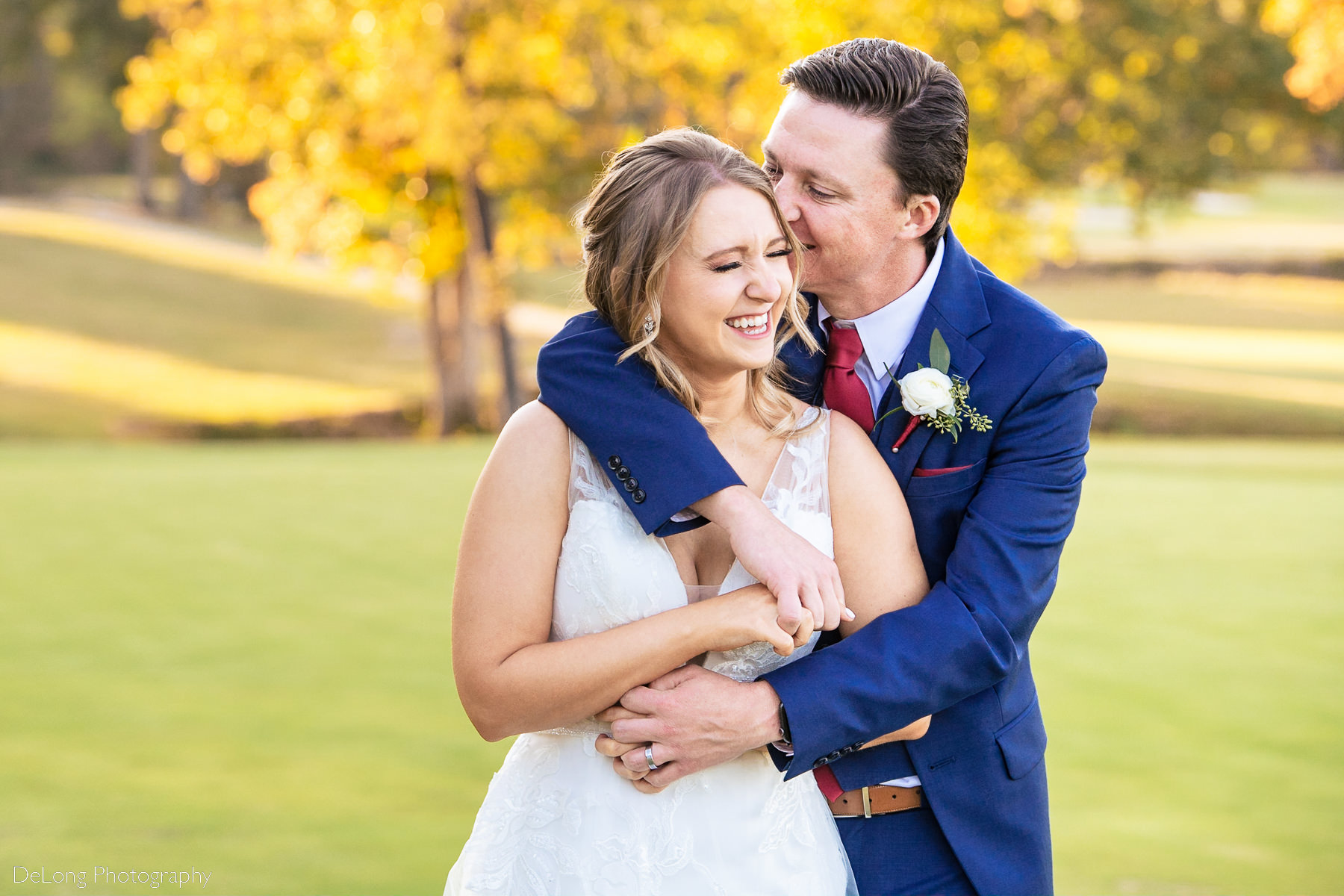 Bride and groom giggling and hugging on the golf course at Pine Island Country Club in Charlotte, NC by Charlotte wedding Photographers DeLong Photography